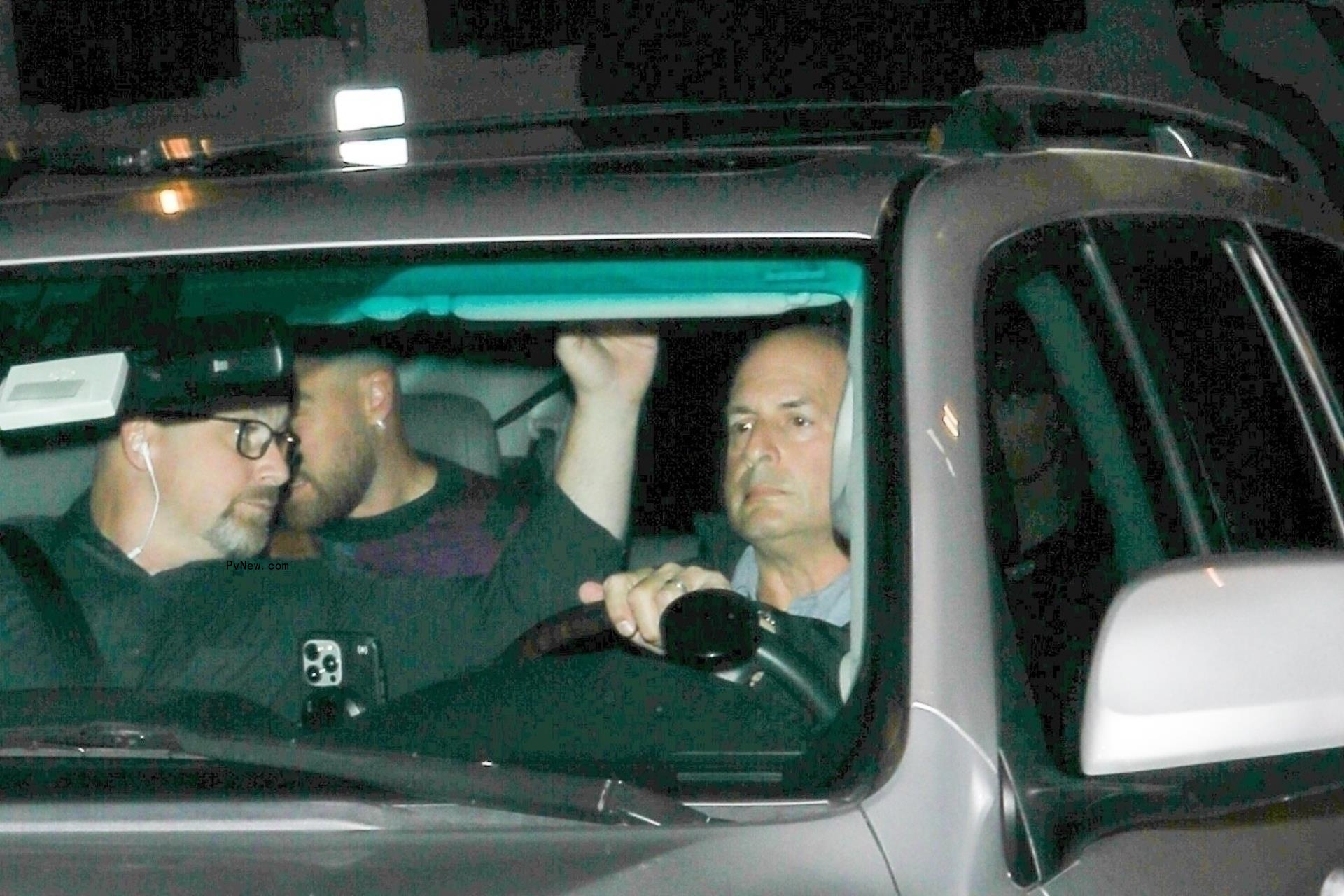 Taylor Swift and Travis Kelce hiding in a car.