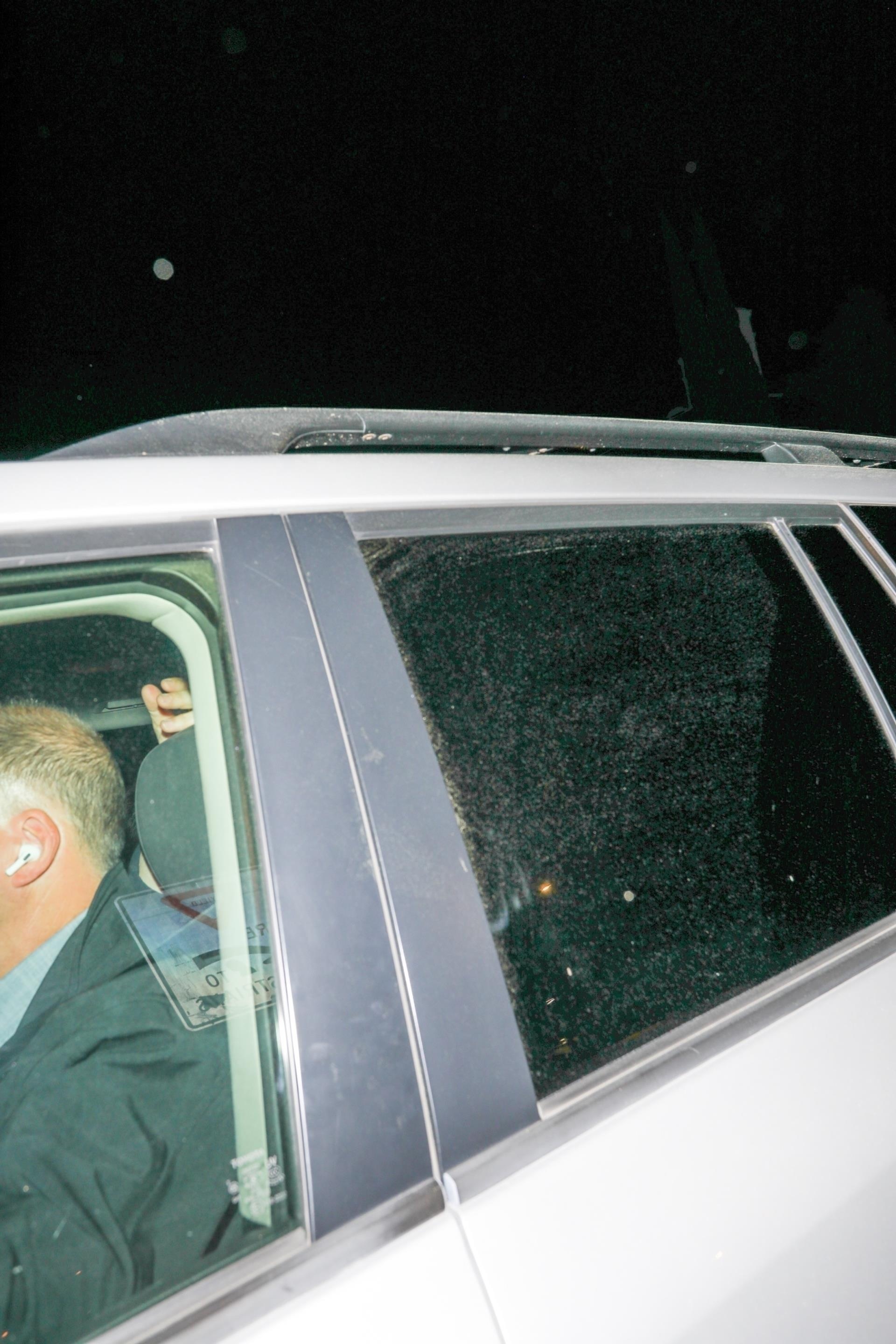 Taylor Swift and Travis Kelce hiding in a car.
