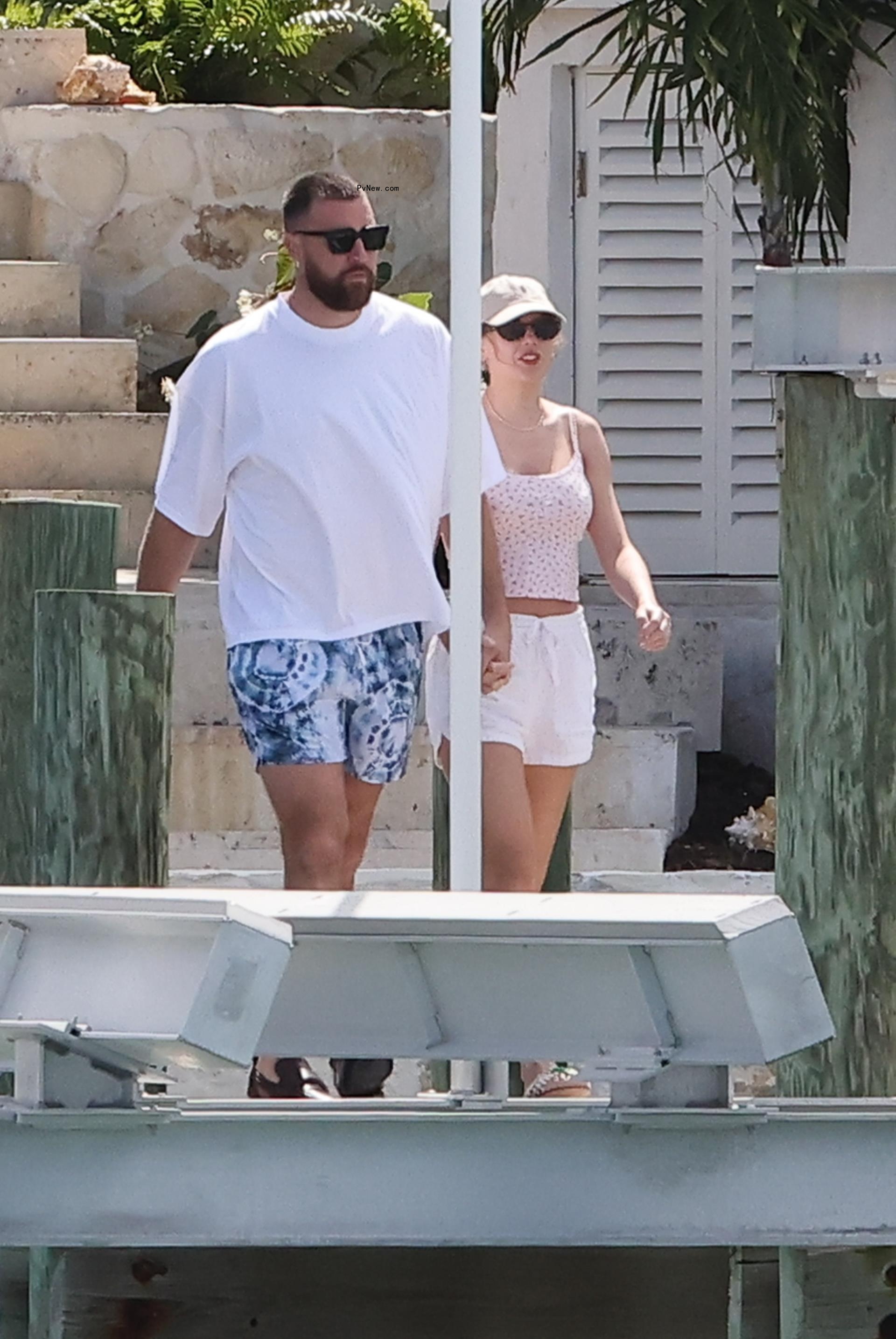 Taylor Swift and Travis Kelce holding hands in the Bahamas.