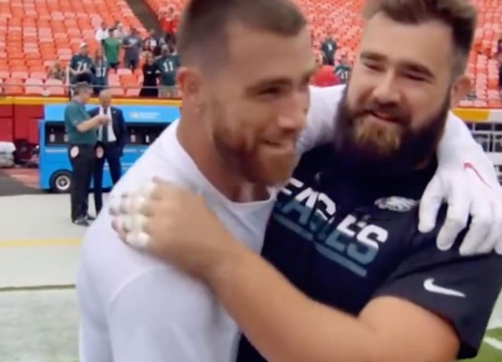 Travis and Jason Kelce hugging on the football field.