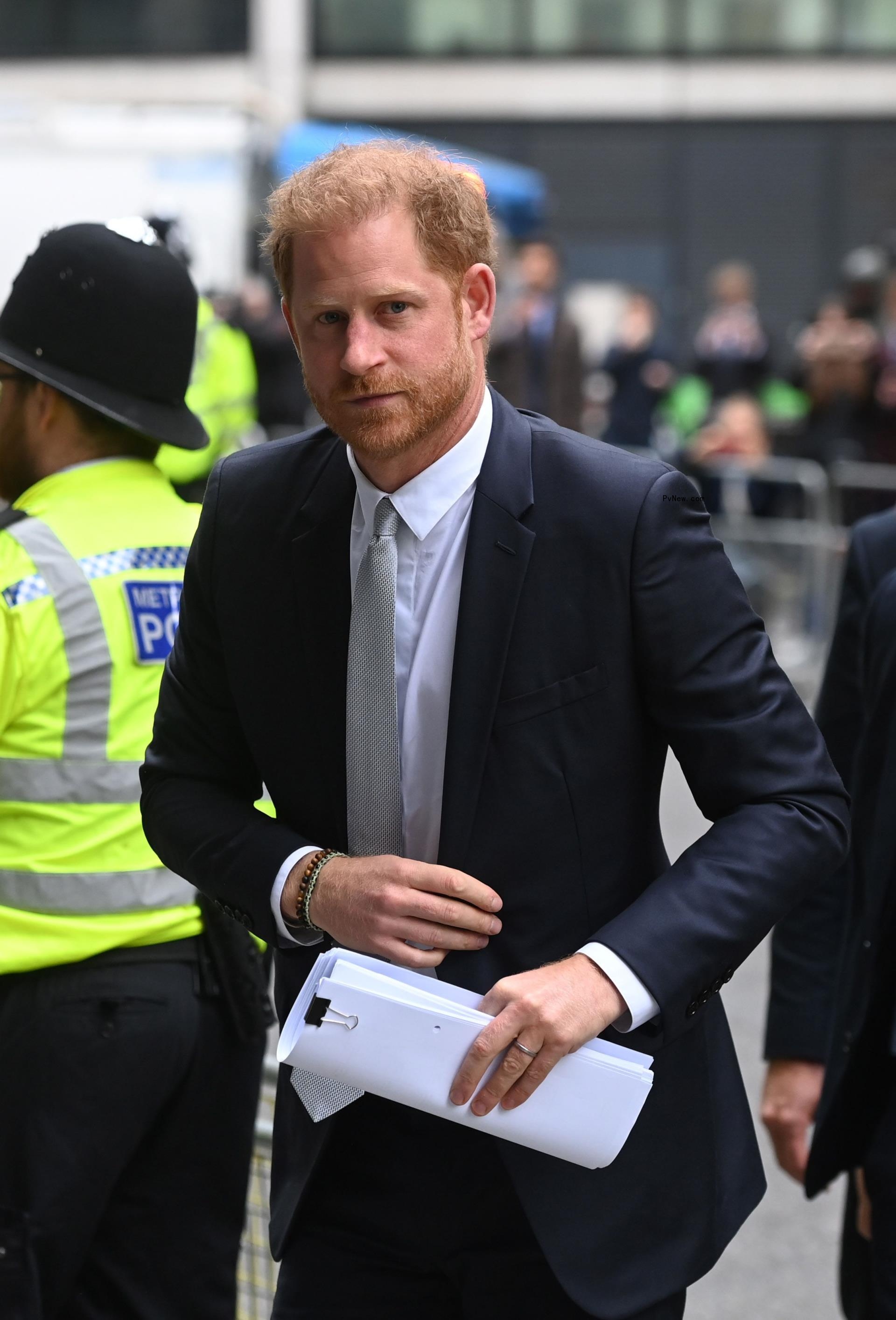 Prince Harry walking into Lo<i></i>ndon High Court with papers in his hands.
