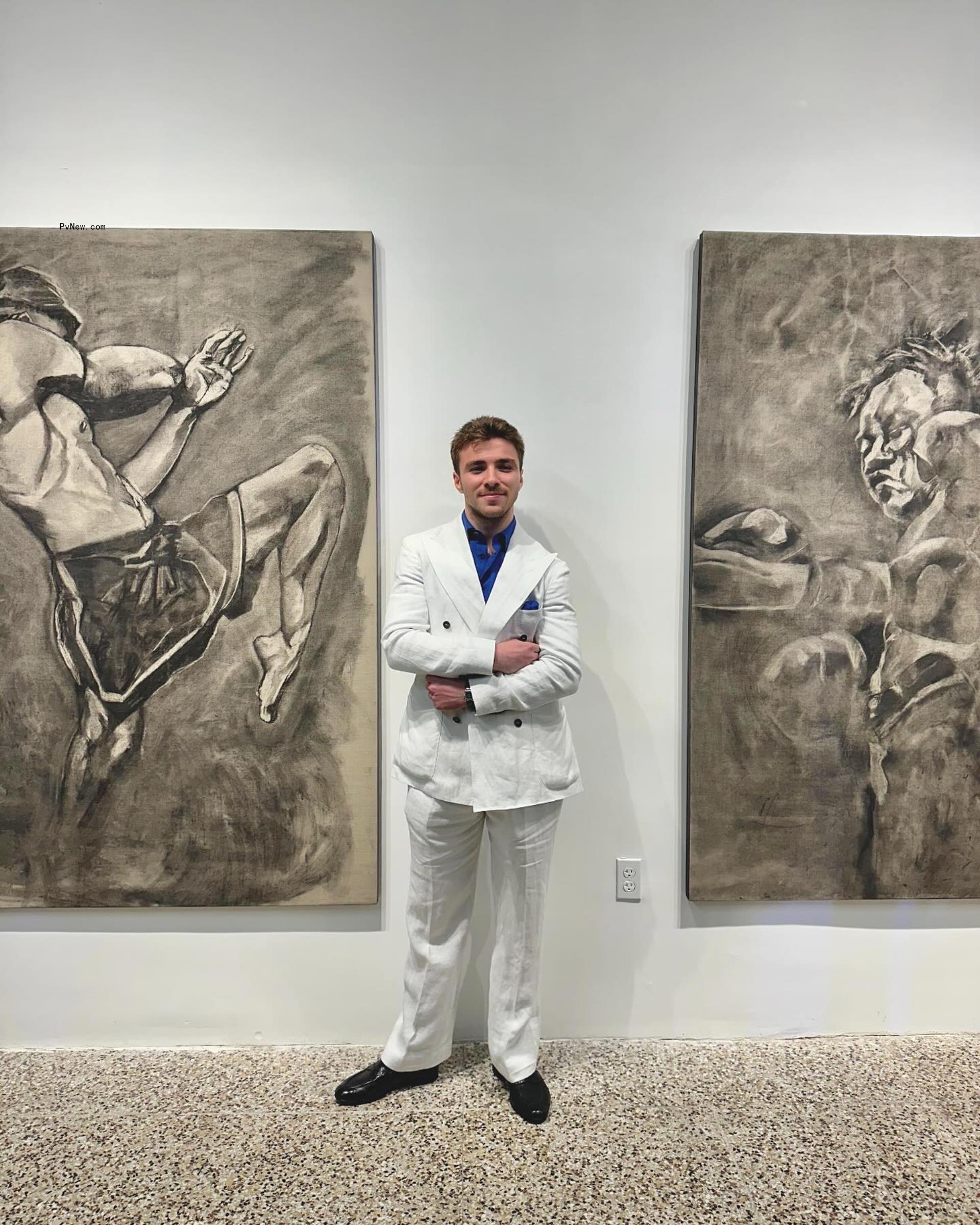 rocco ritchie standing in between two of his art pieces