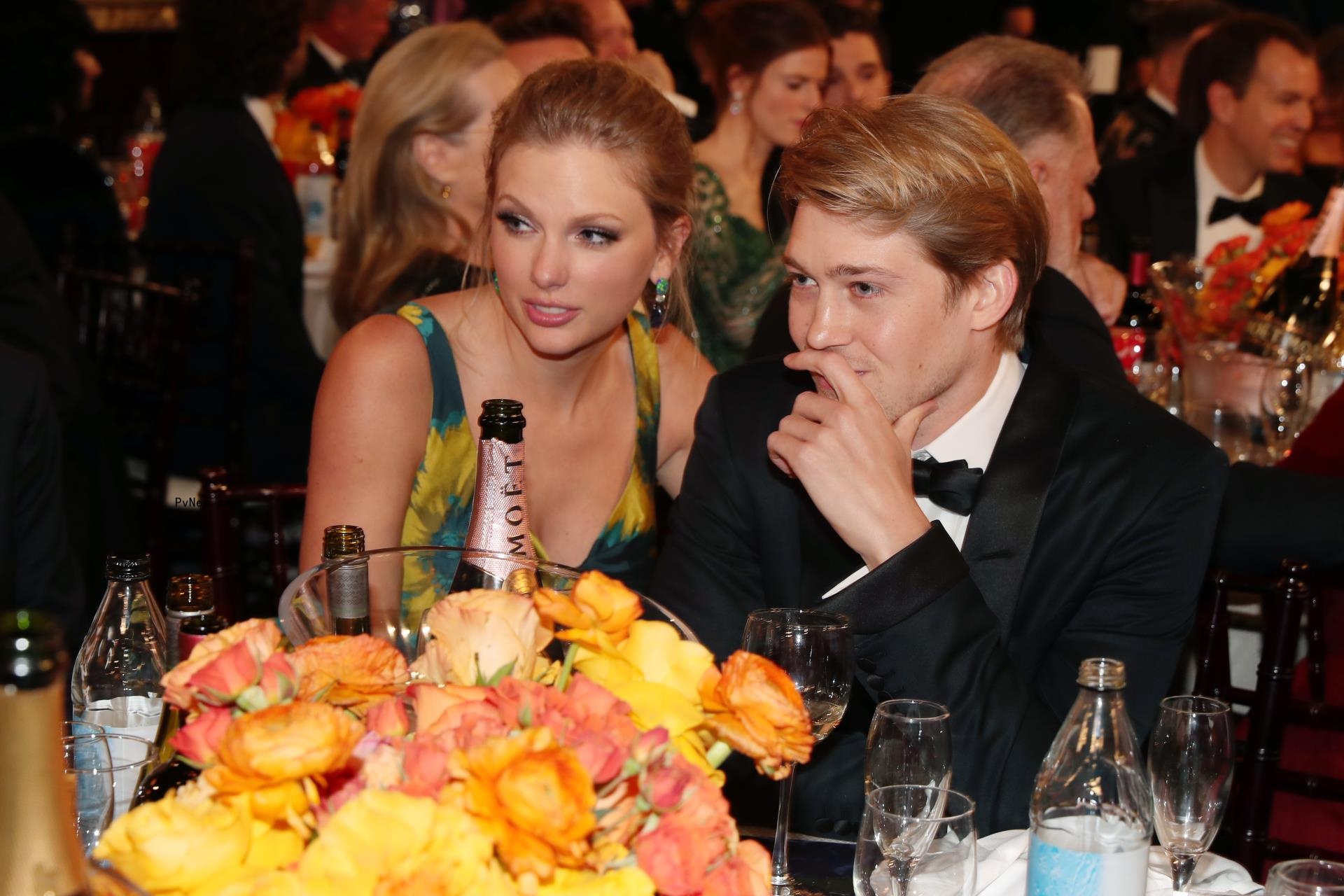 Taylor Swift, Joe Alwyn sitting together at a table