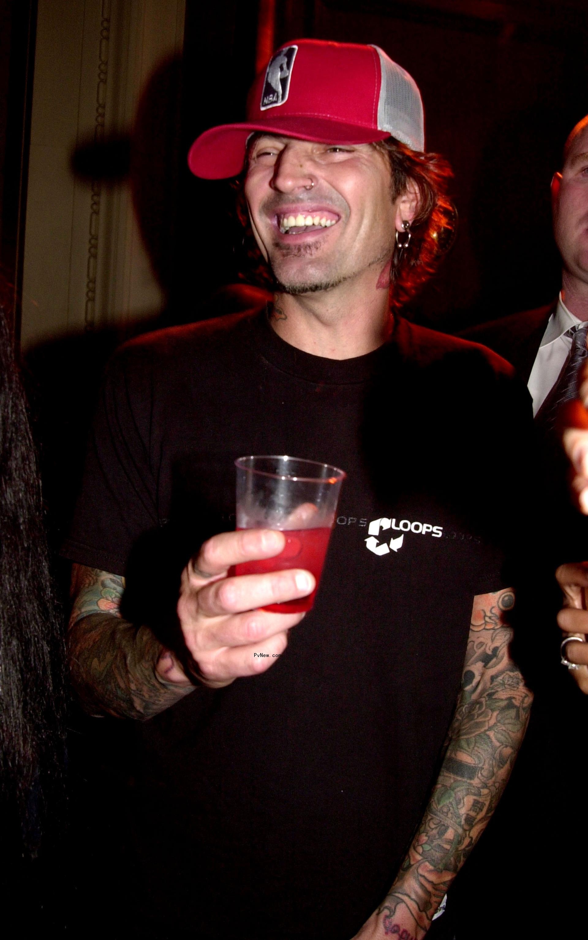 Tommy Lee holding a drink.