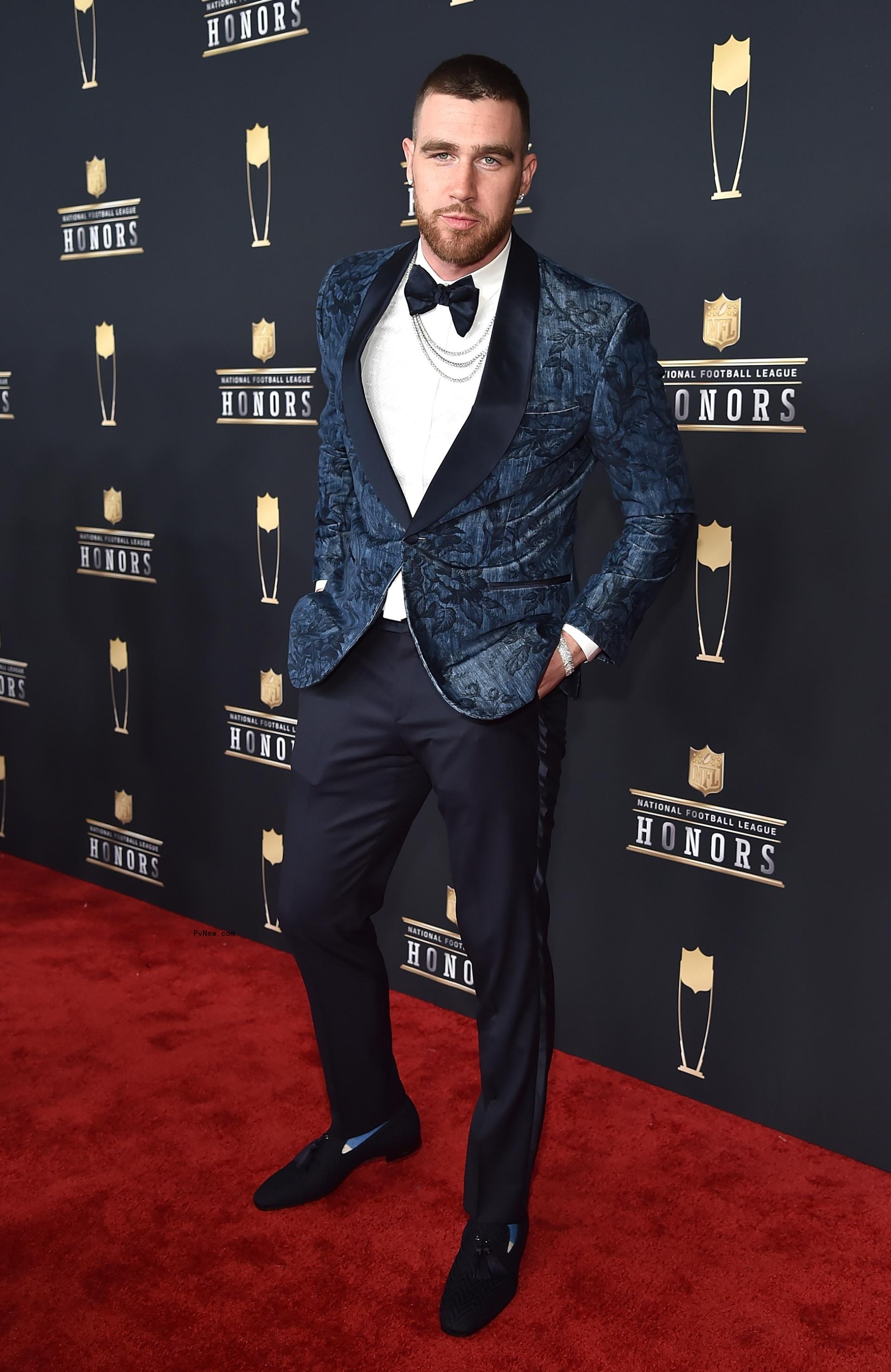 Travis Kelce posing on a red carpet
