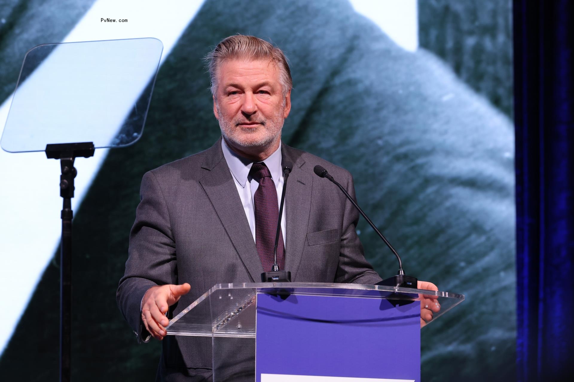 alec baldwin standing in a podium