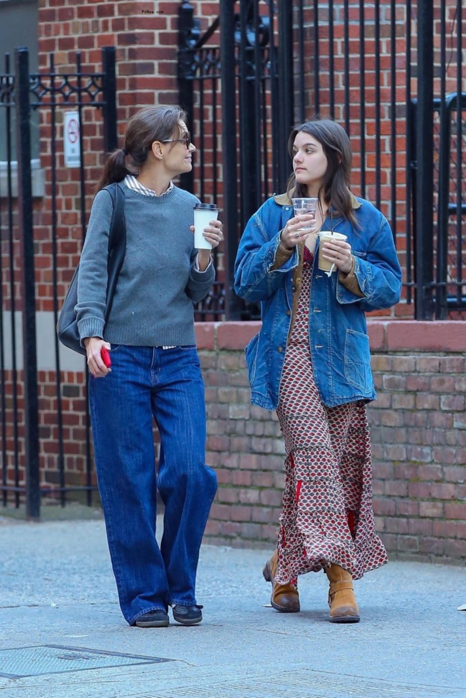 Katie Holmes and Suri Cruise walking with coffee in New York City.