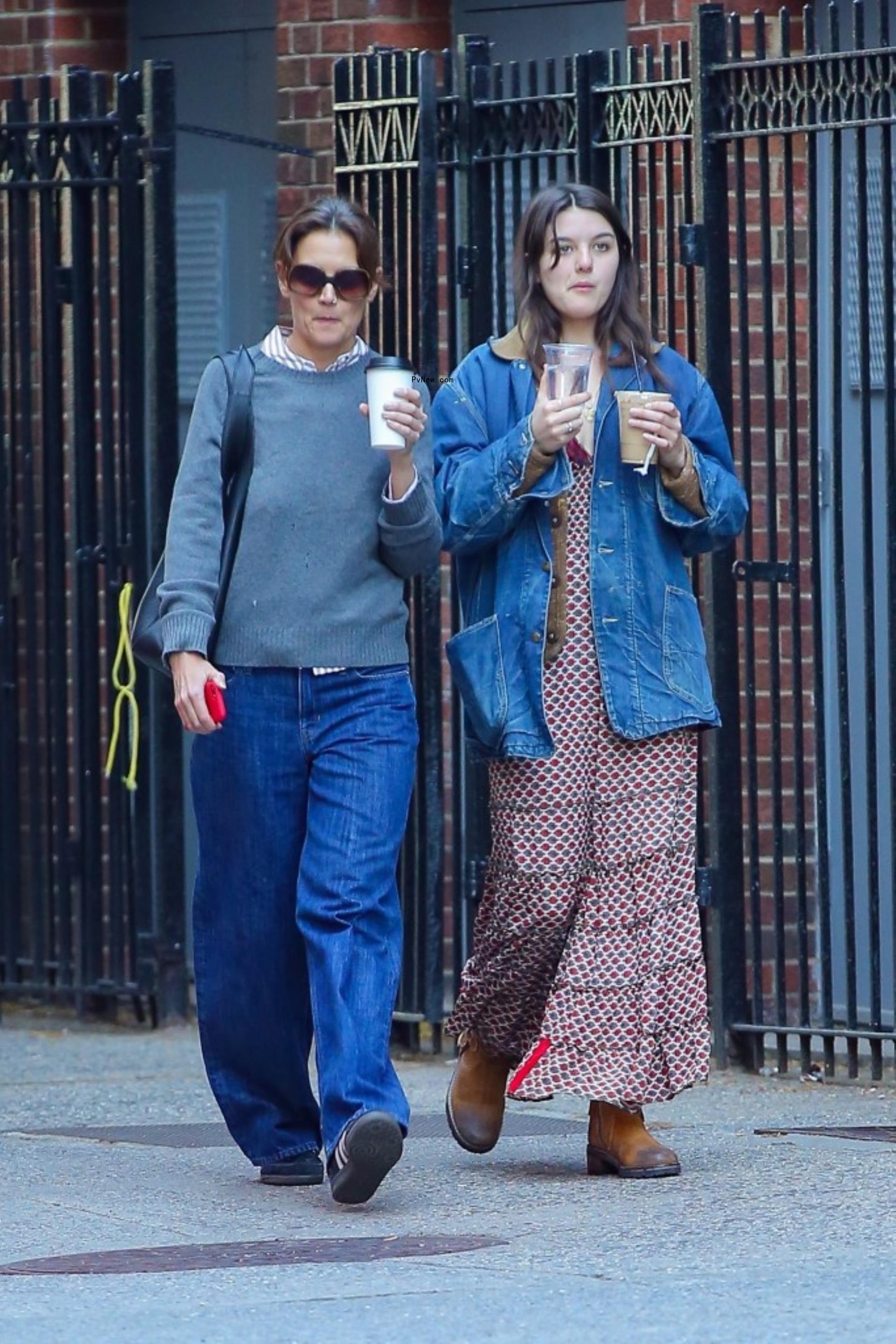 Katie Holmes and Suri Cruise walking with coffee in New York City.