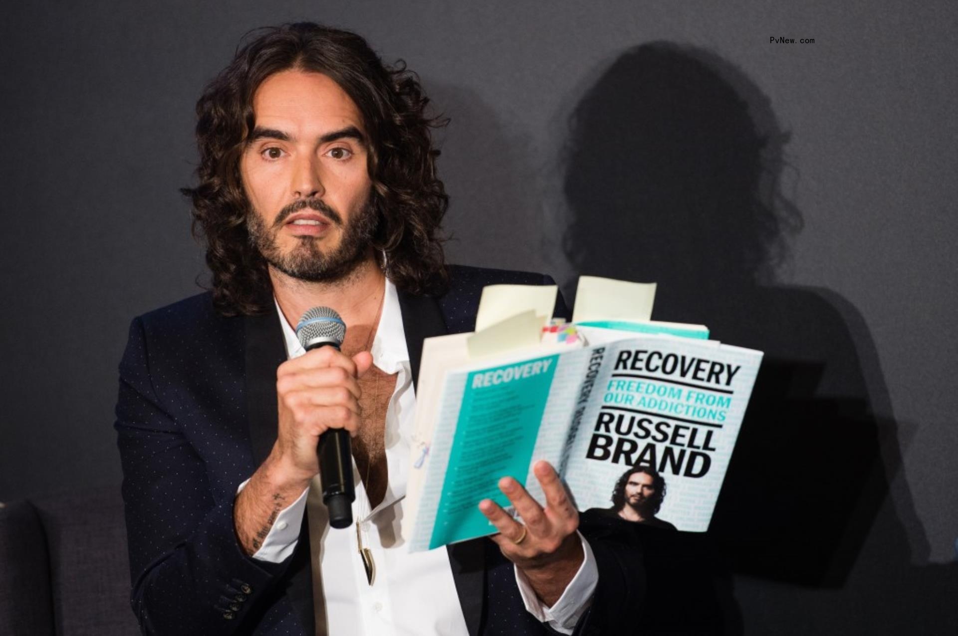 Russell Brand reading a book