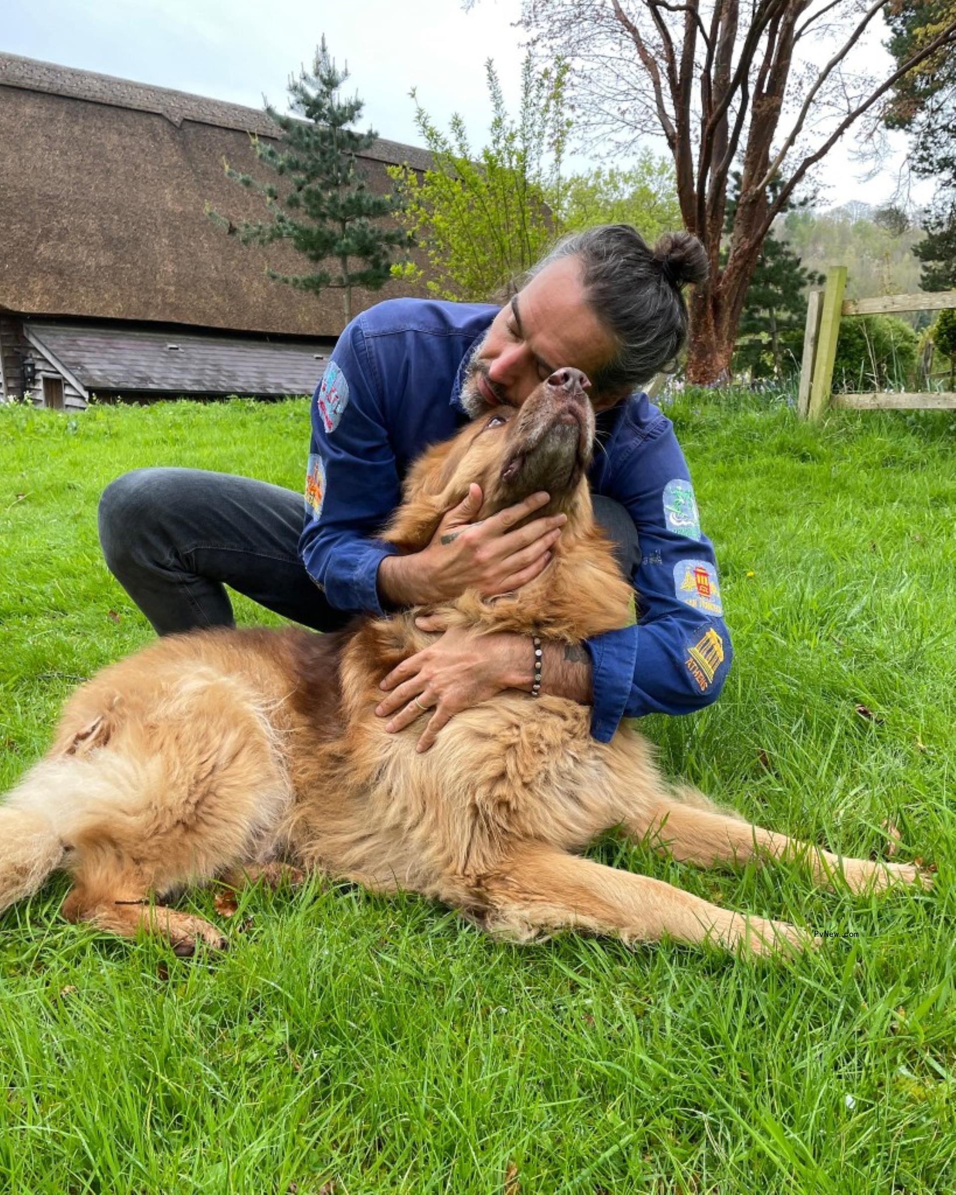 Russell Brand hugging a dog