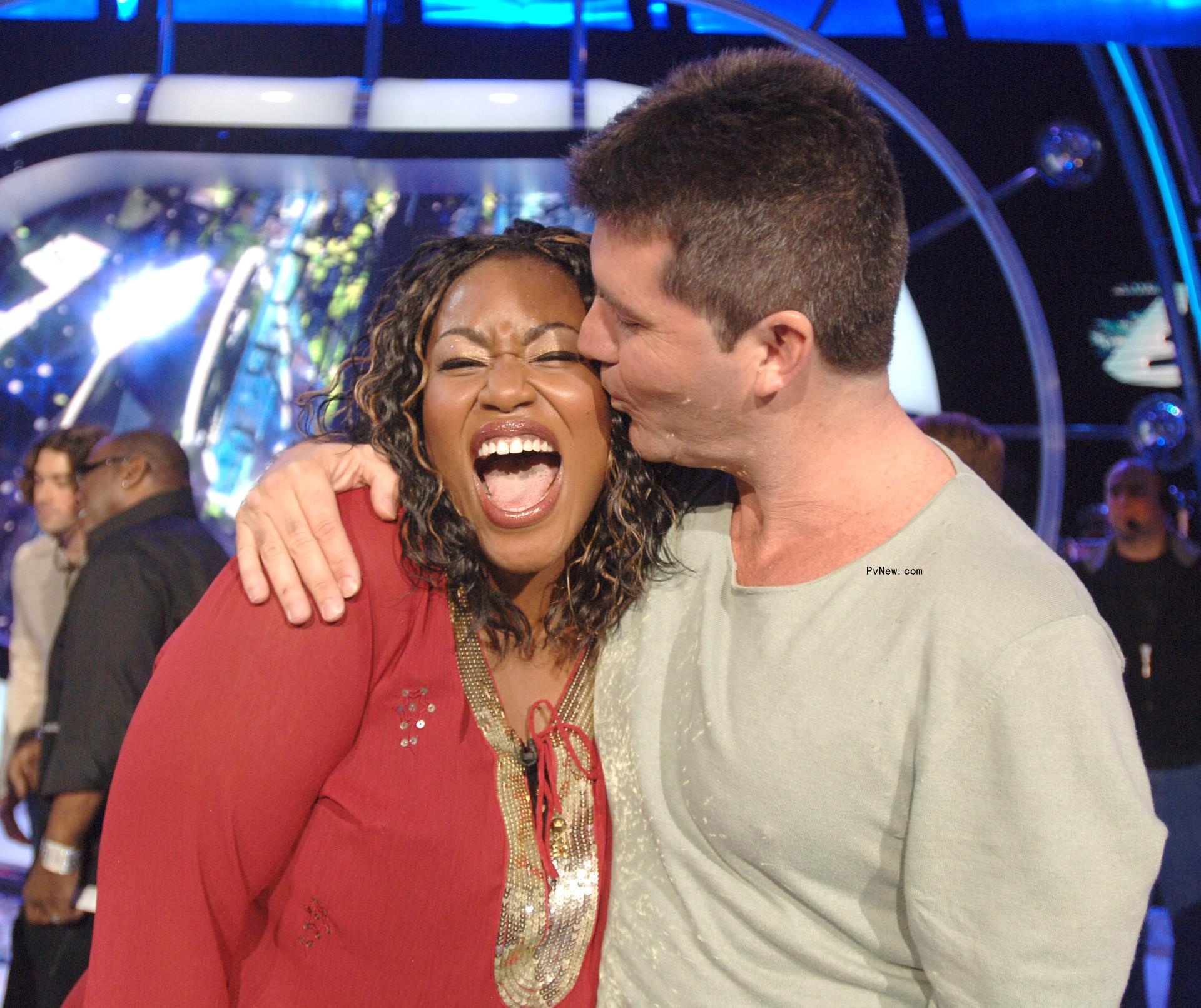 Simon Cowell kissing Mandisa ont he cheek.