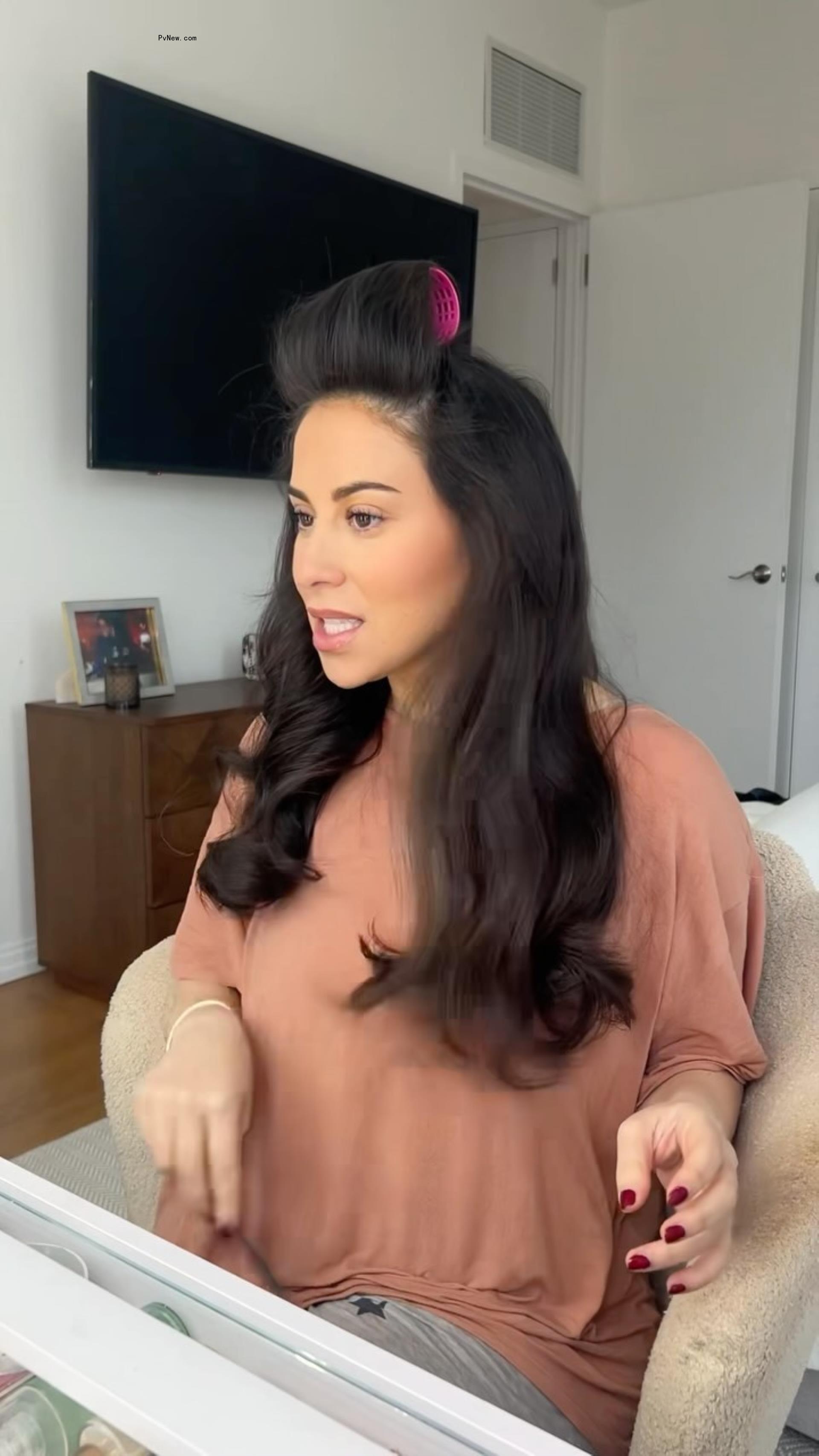 Claudia Oshry wearing a hair curler. 