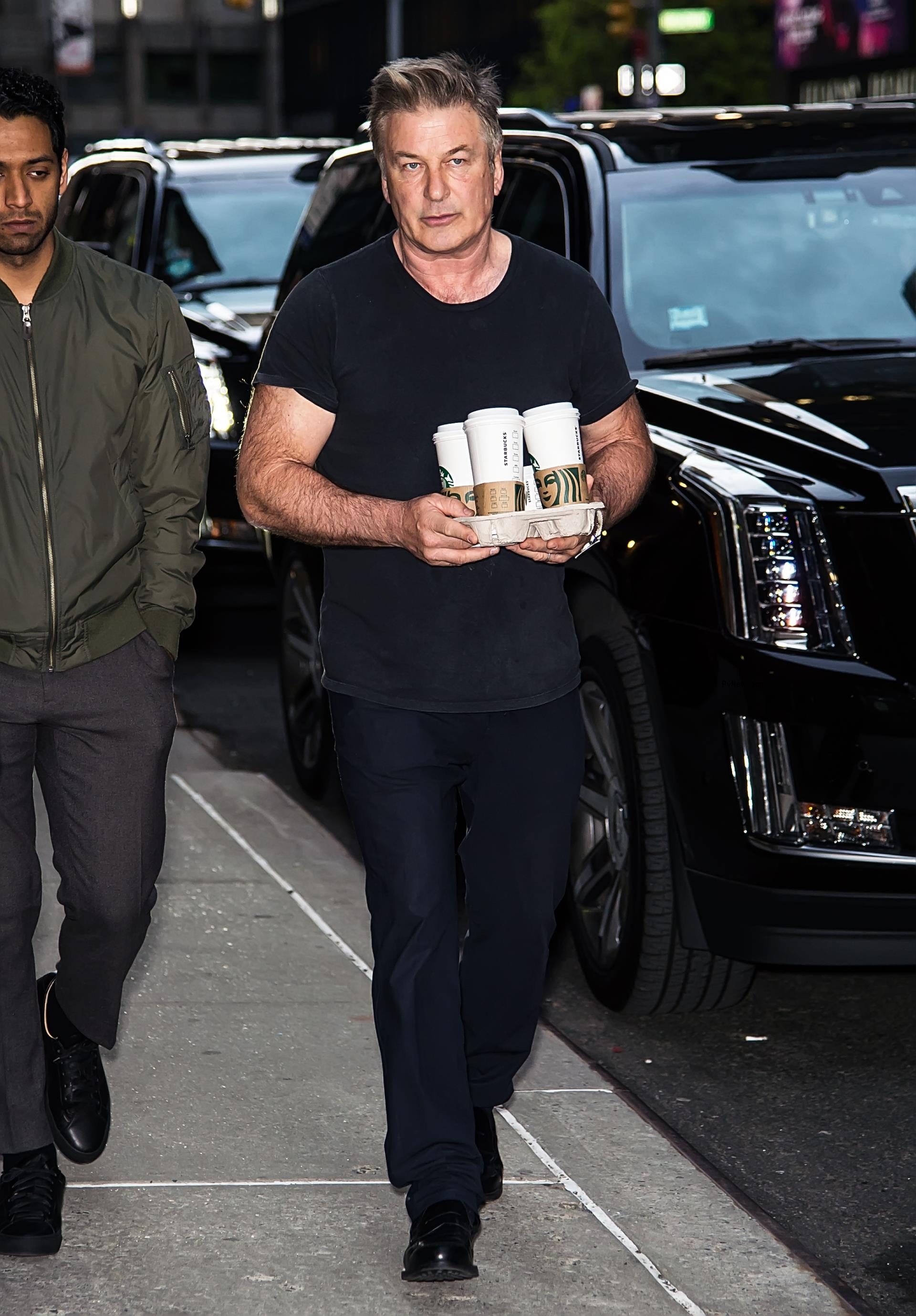 Alec Baldwin carrying drinks.