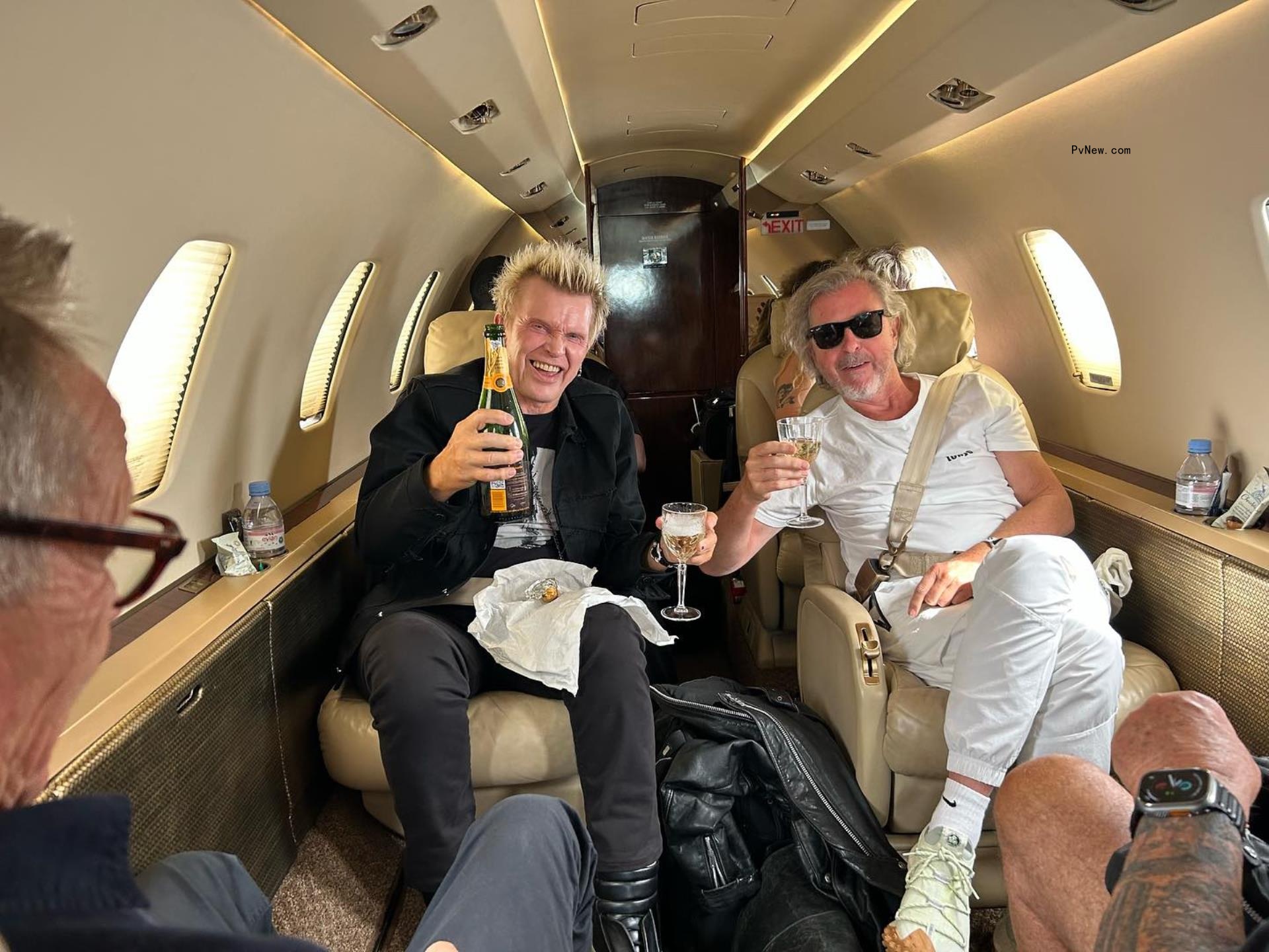 Billy Idol sitting in a plane with a friend