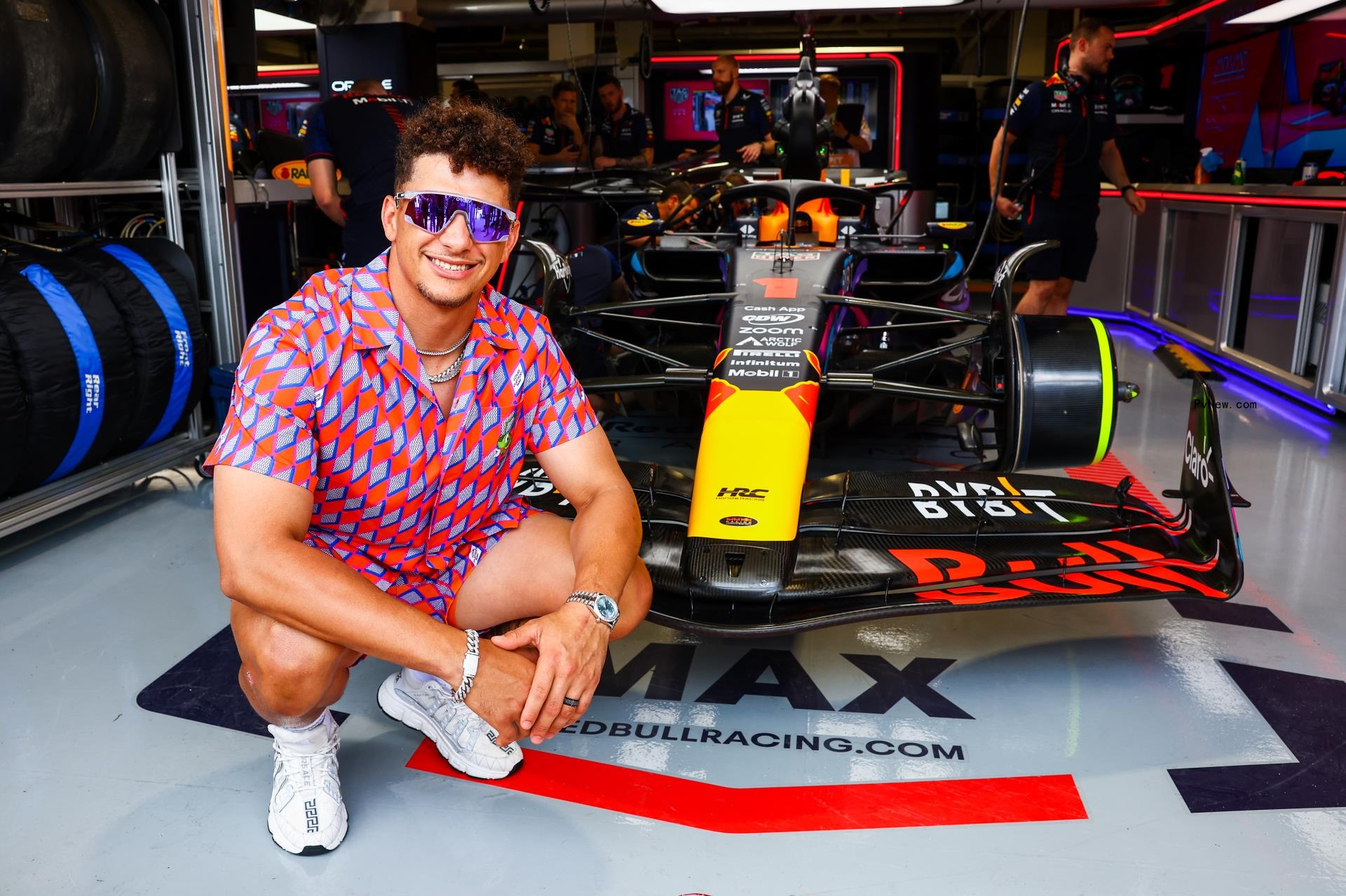 Patrick Mahomes in front of a car.