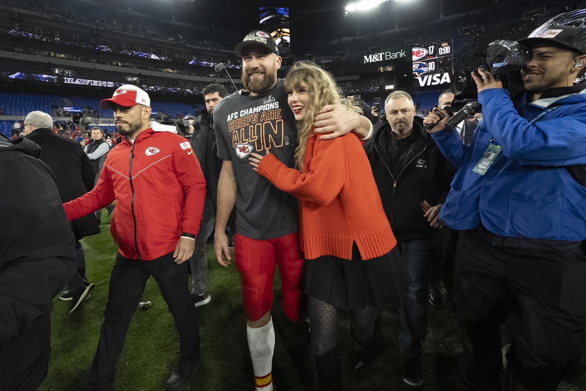 Travis Kelce and Taylor Swift on the football field.