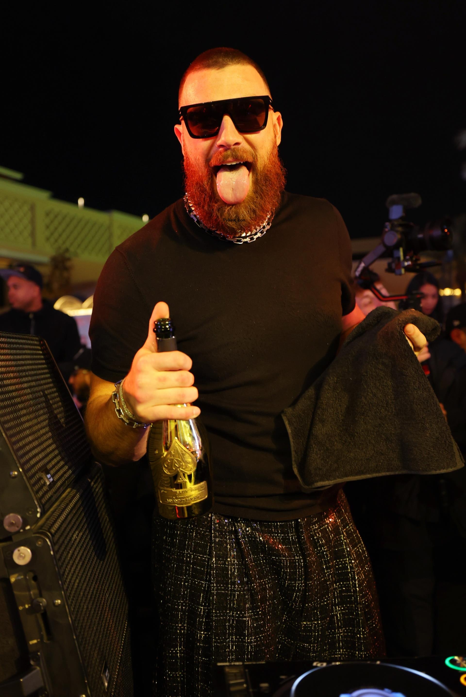 Travis Kelce holding a bottle.
