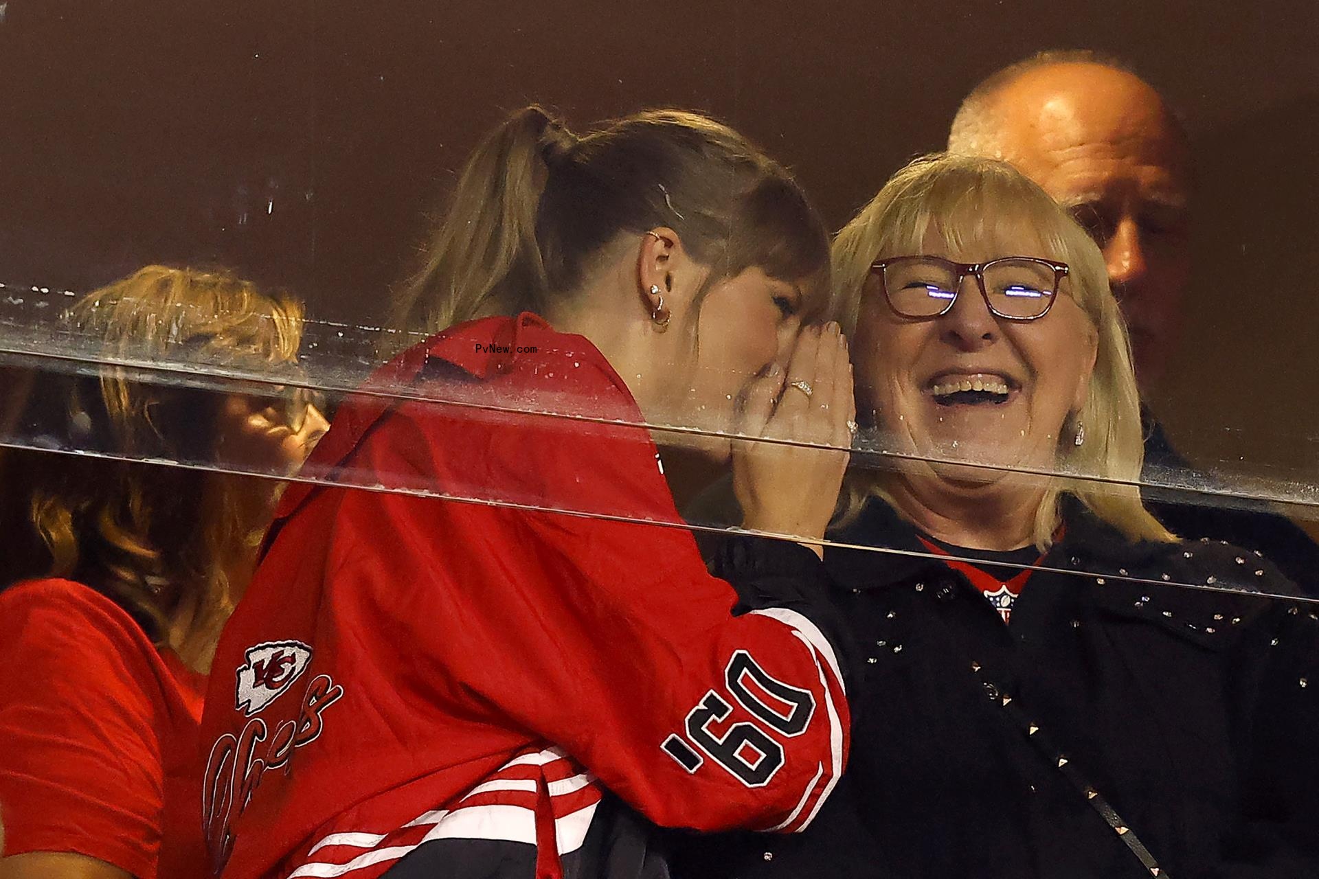Taylor Swift whispering in Do<i></i>nna Kelce's ear.