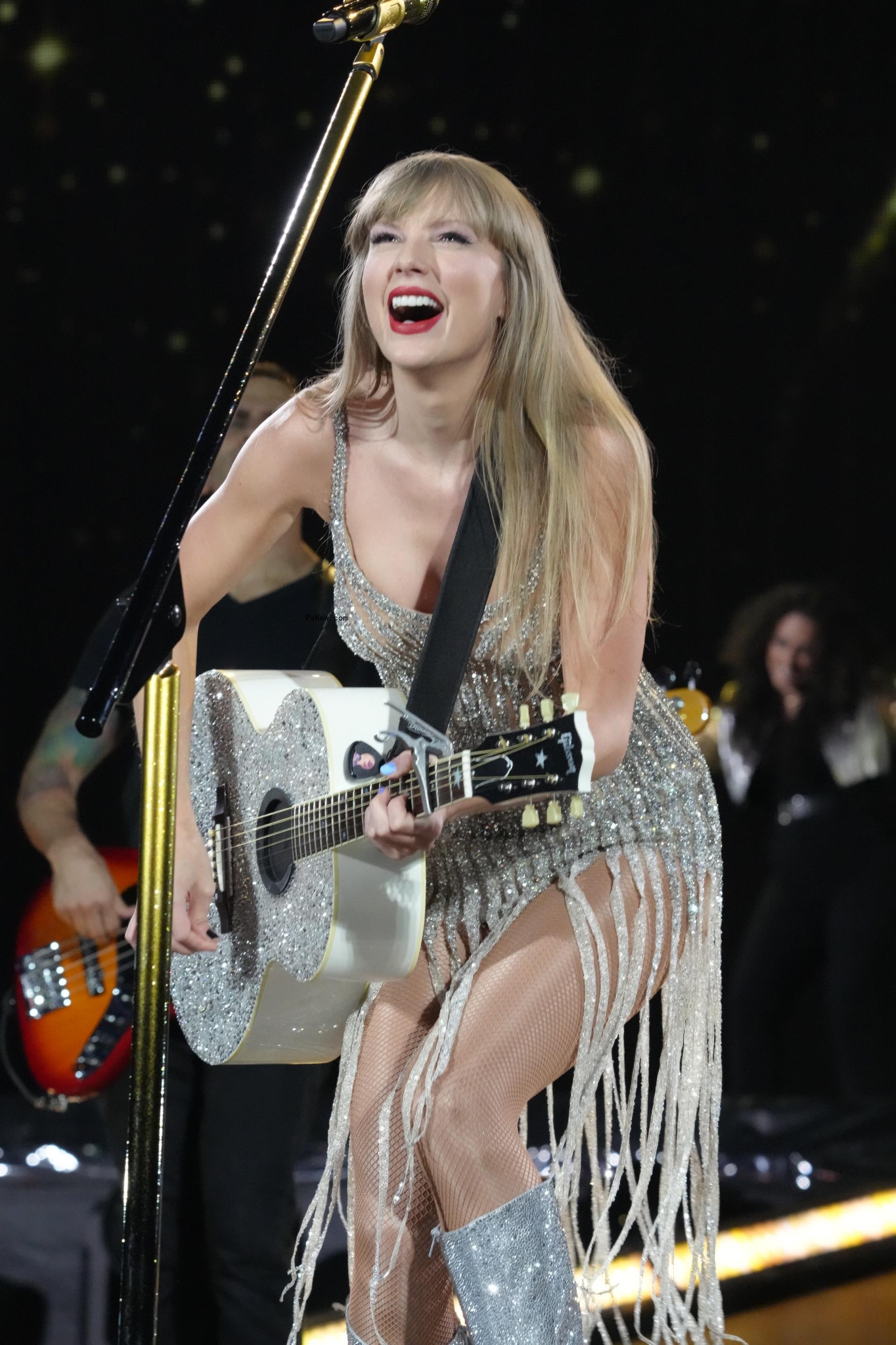 Taylor Swift o<i></i>nstage and playing the guitar.