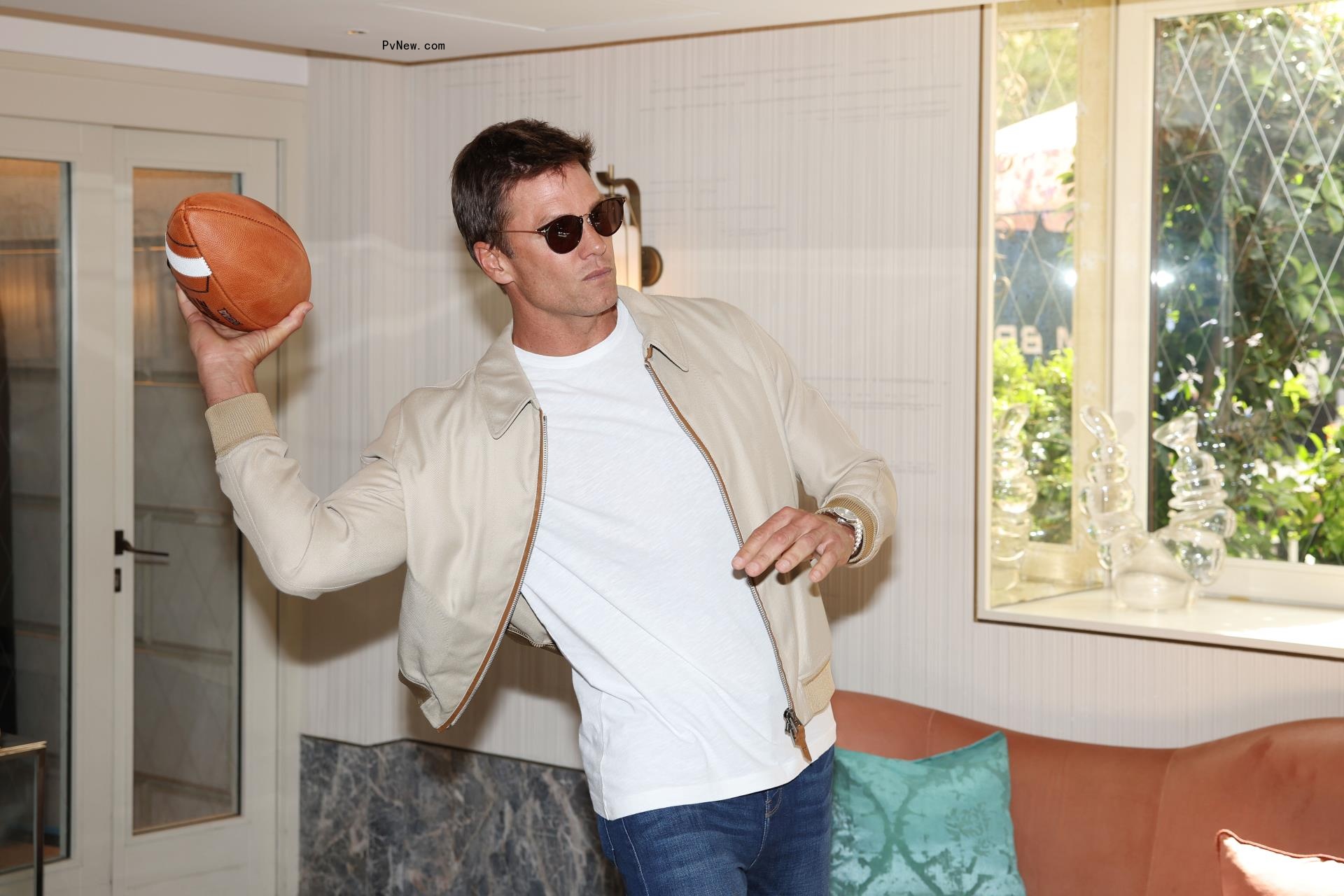 Tom Brady holding football.