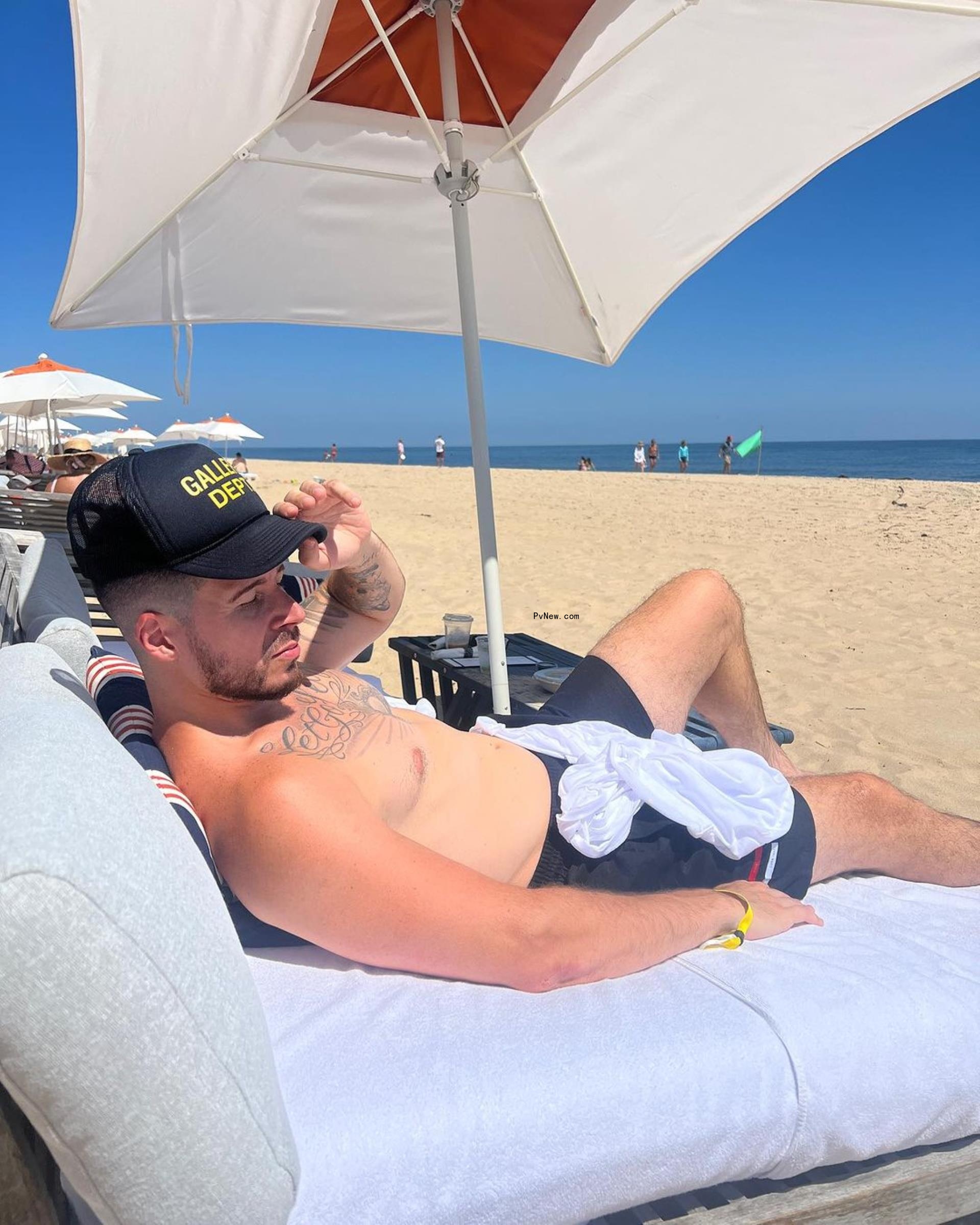 Vinny Guadagnino sitting on a beach