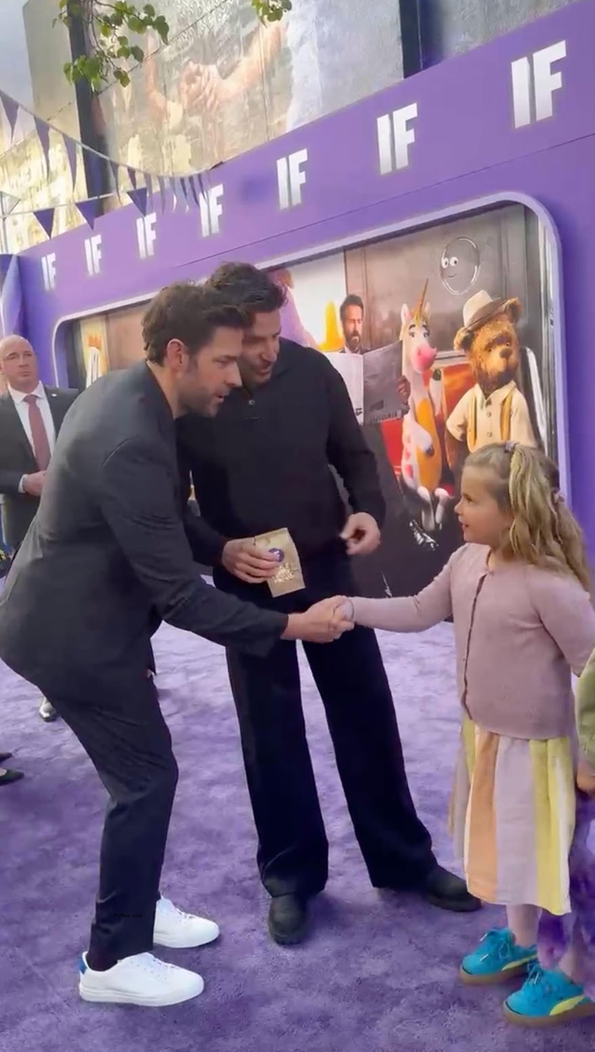John Krasinski shaking hands with Bradley Cooper's daughter, Lea, at the 