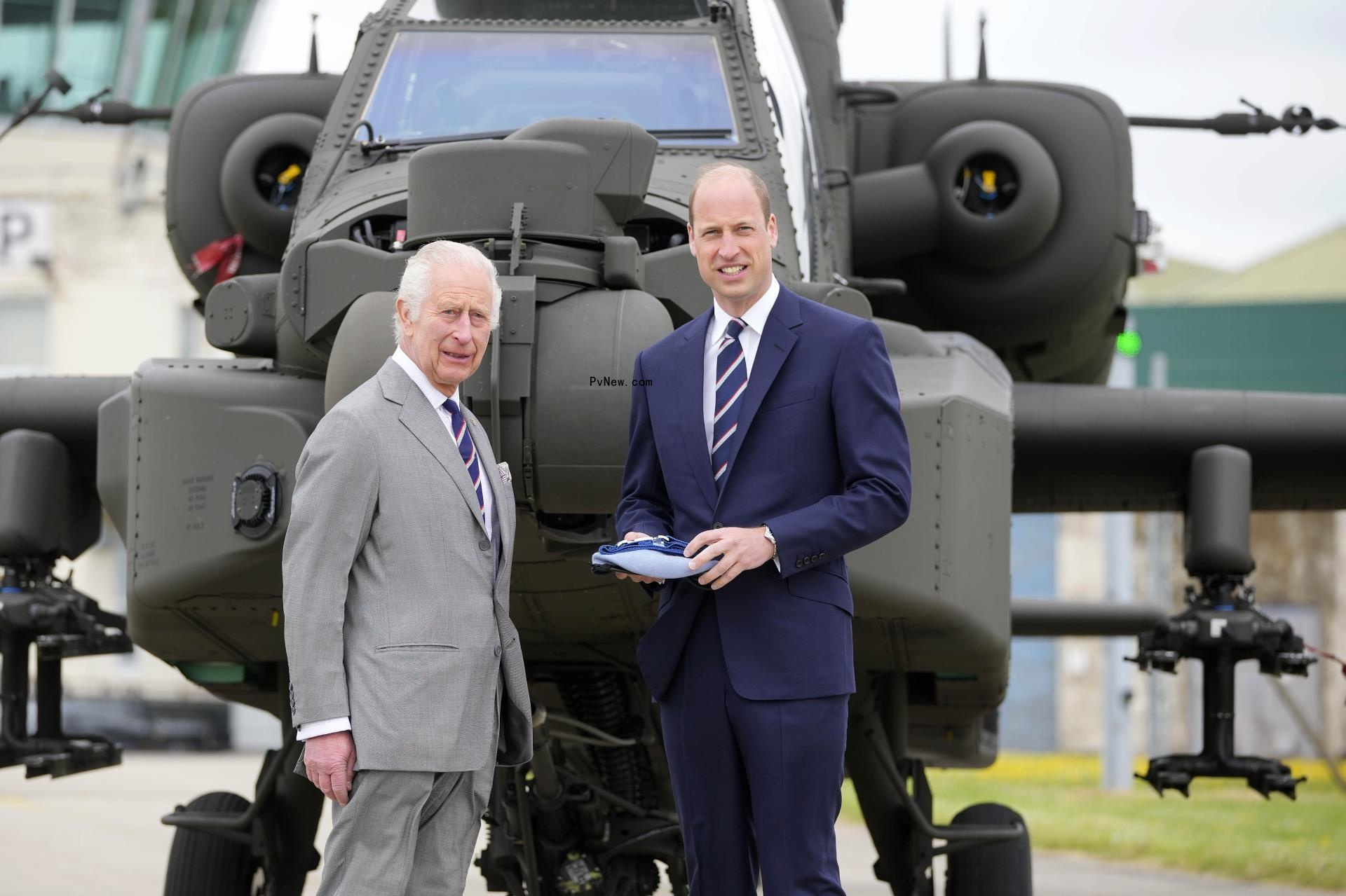 King Charles and Prince William posing in front of a helicopter