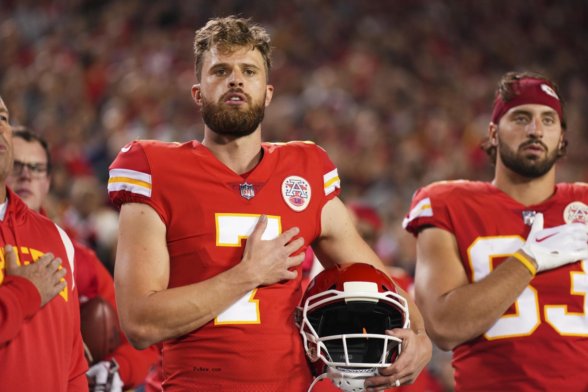 harrison butker in chiefs uniform with his hand on his heart