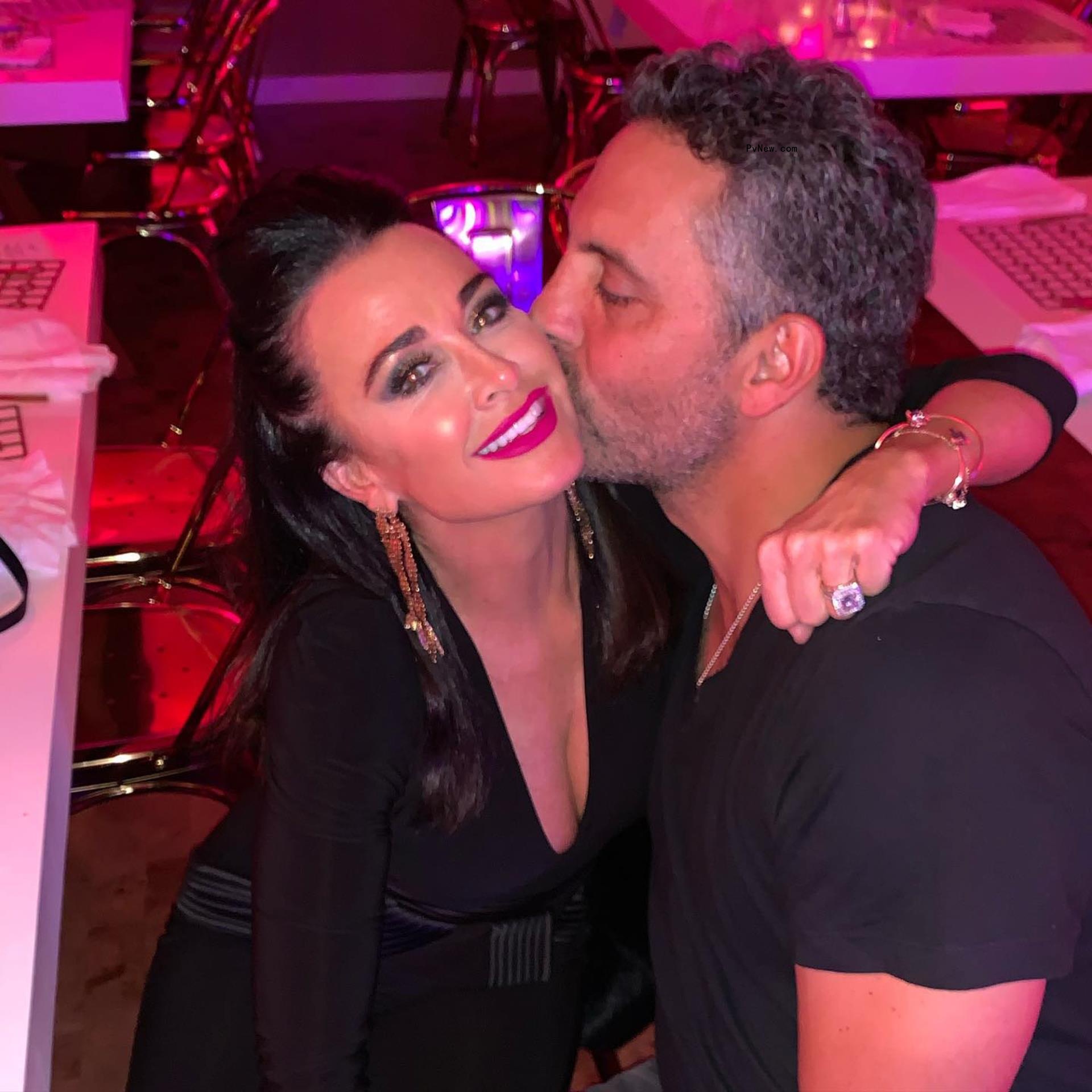 Mauricio Umansky kissing Kyle Richards on the cheek.