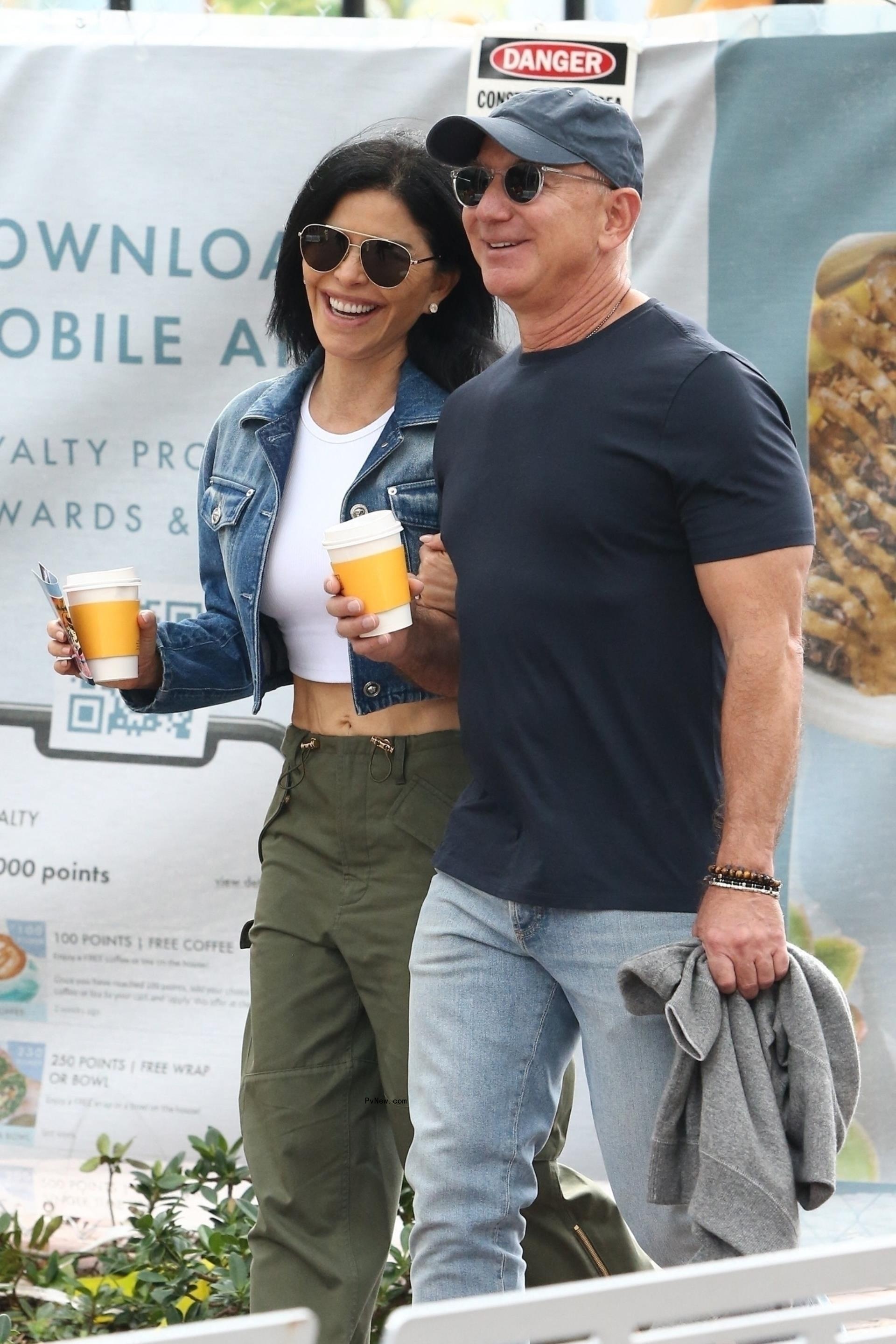 Jeff Bezos and fiancée Lauren Sánchez walking with coffees.