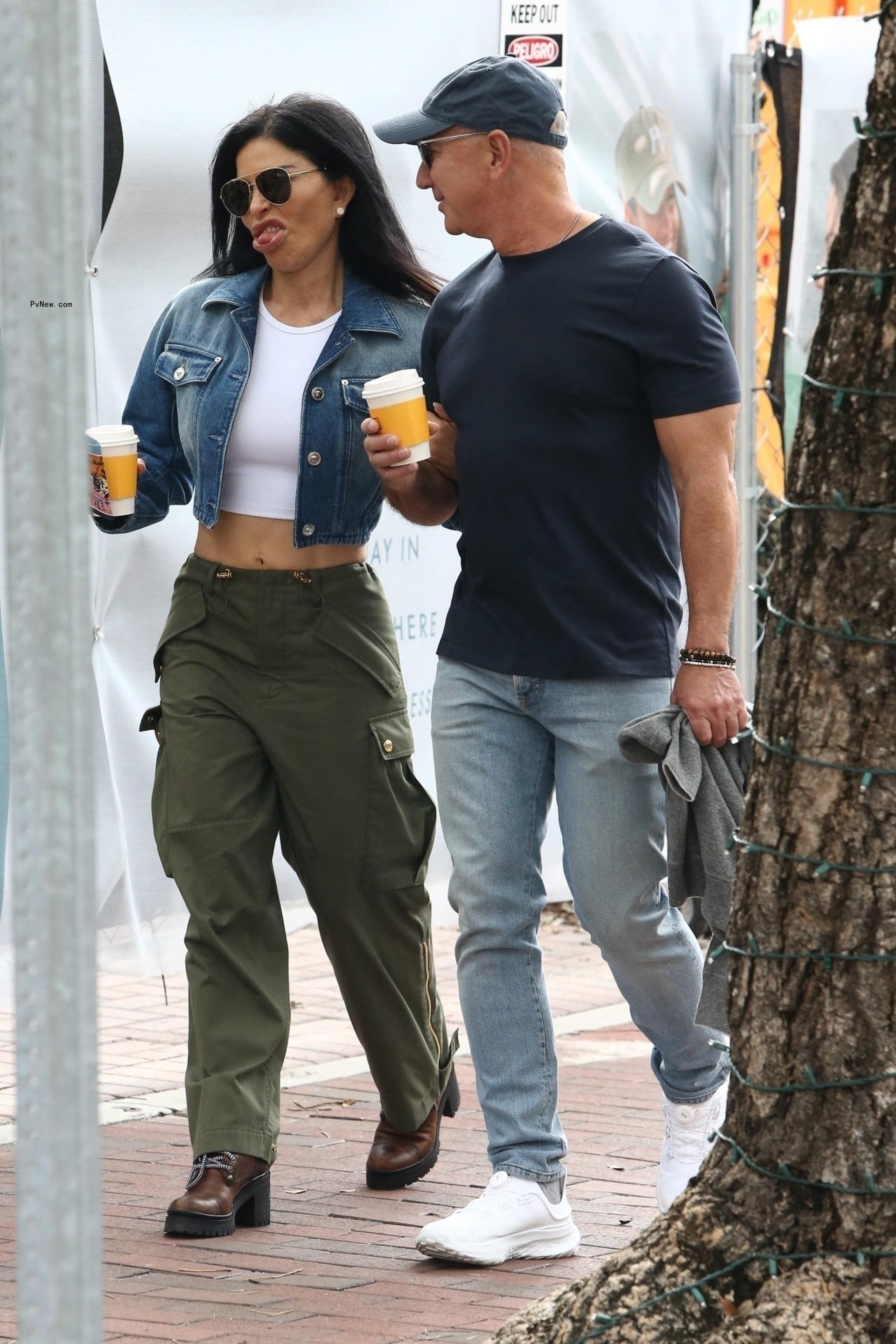 Jeff Bezos and fiancée Lauren Sánchez walking with coffees.