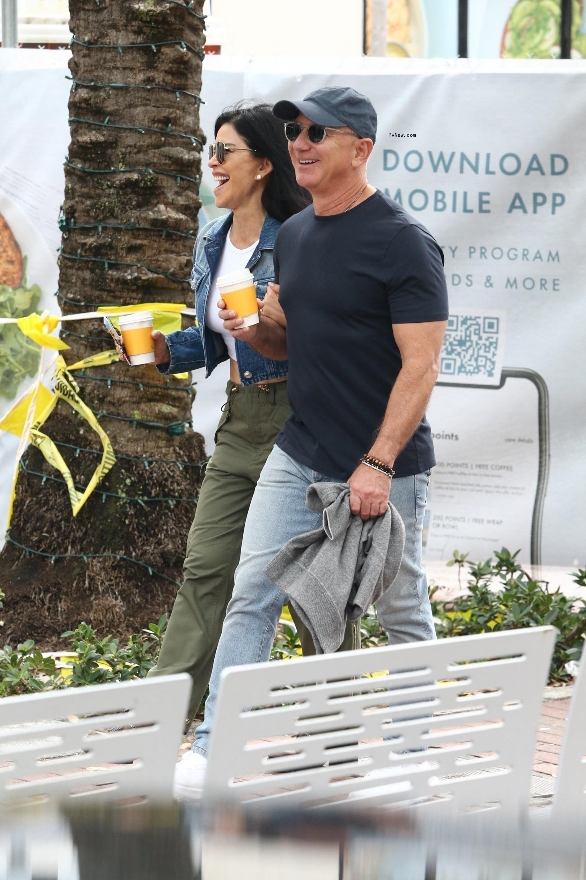 Jeff Bezos and his fiancée Lauren Sanchez walking with coffees.