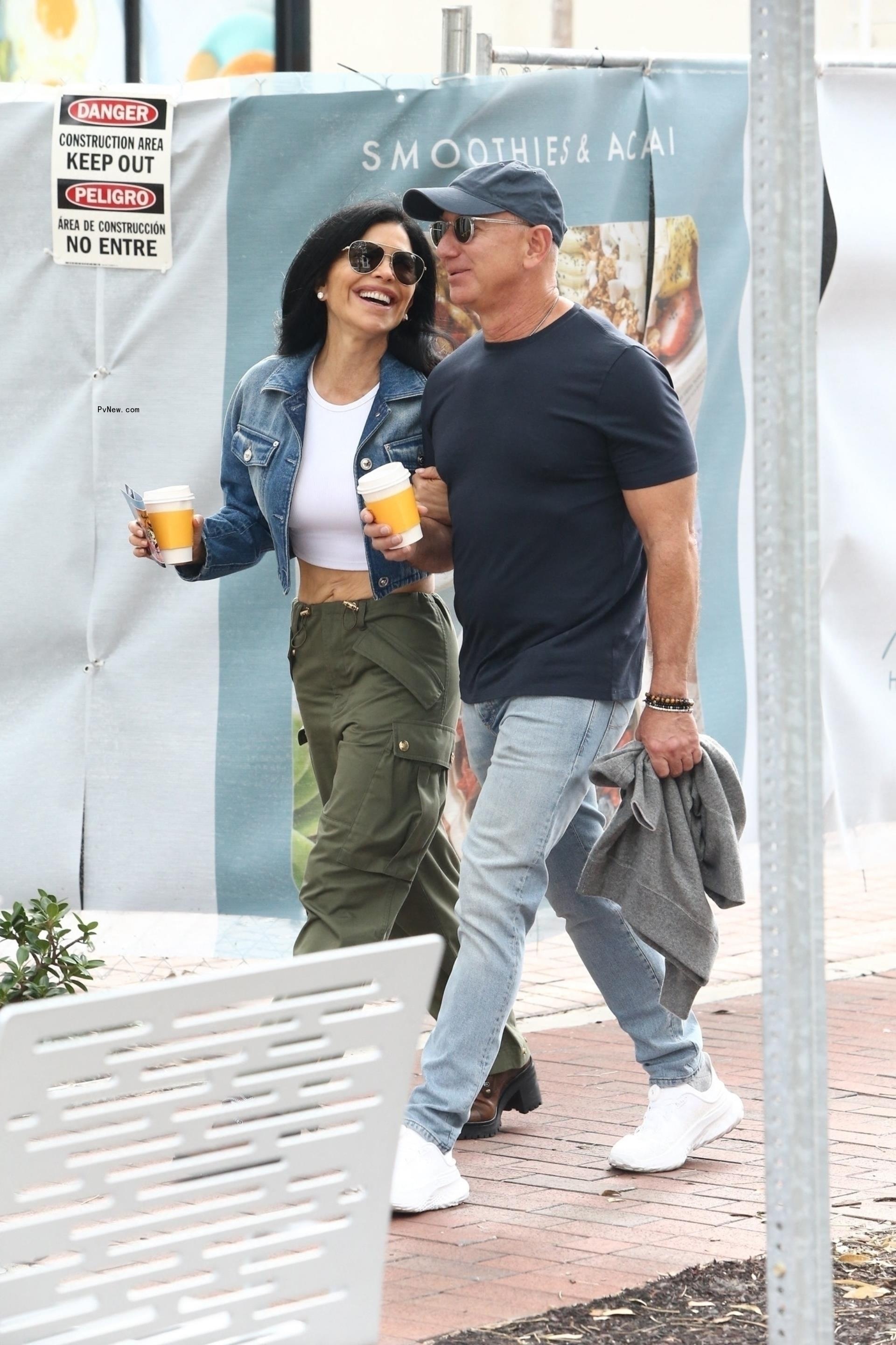 Jeff Bezos and fiancée Lauren Sánchez walking with coffees.
