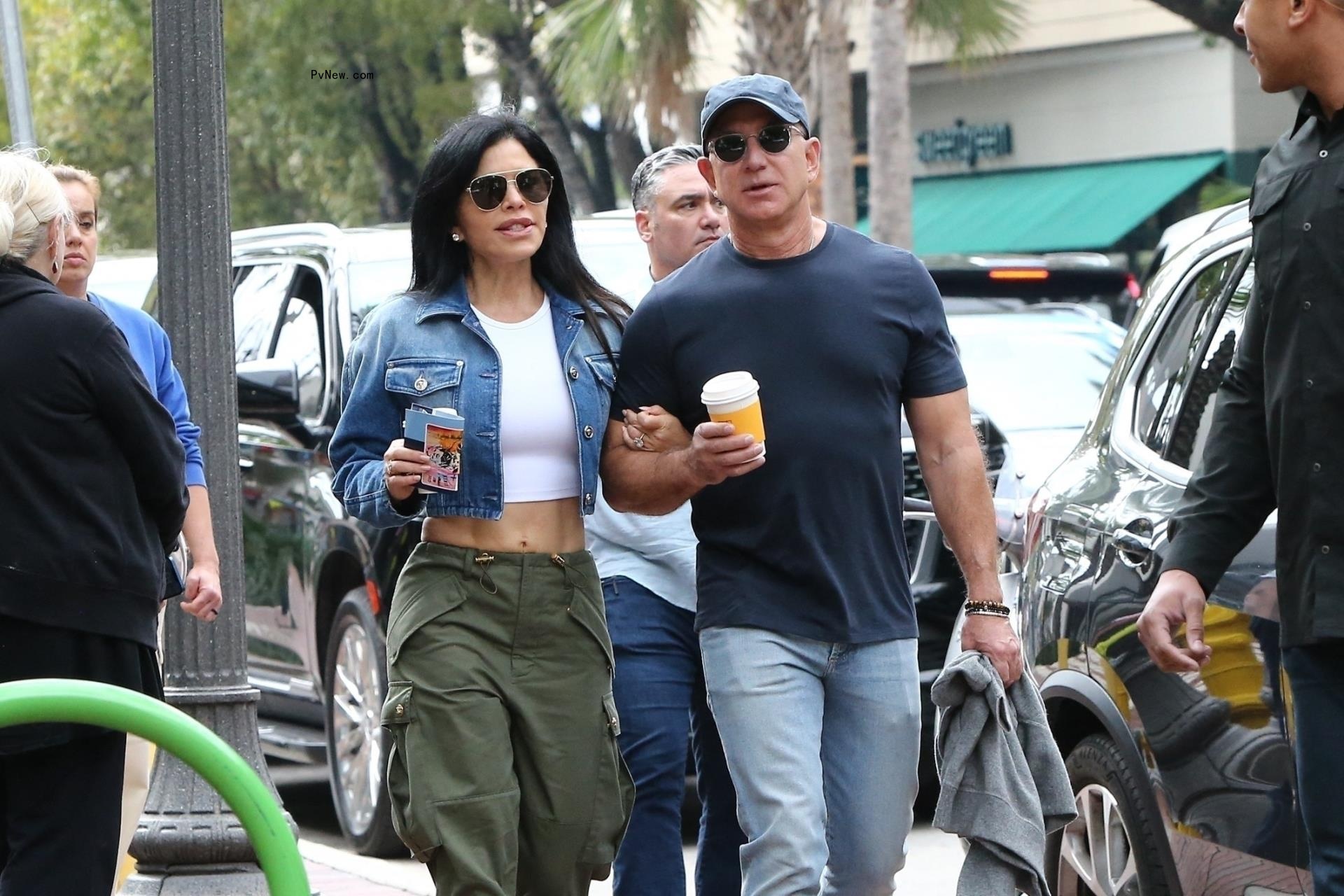 Jeff Bezos and fiancée Lauren Sánchez walking with coffees.