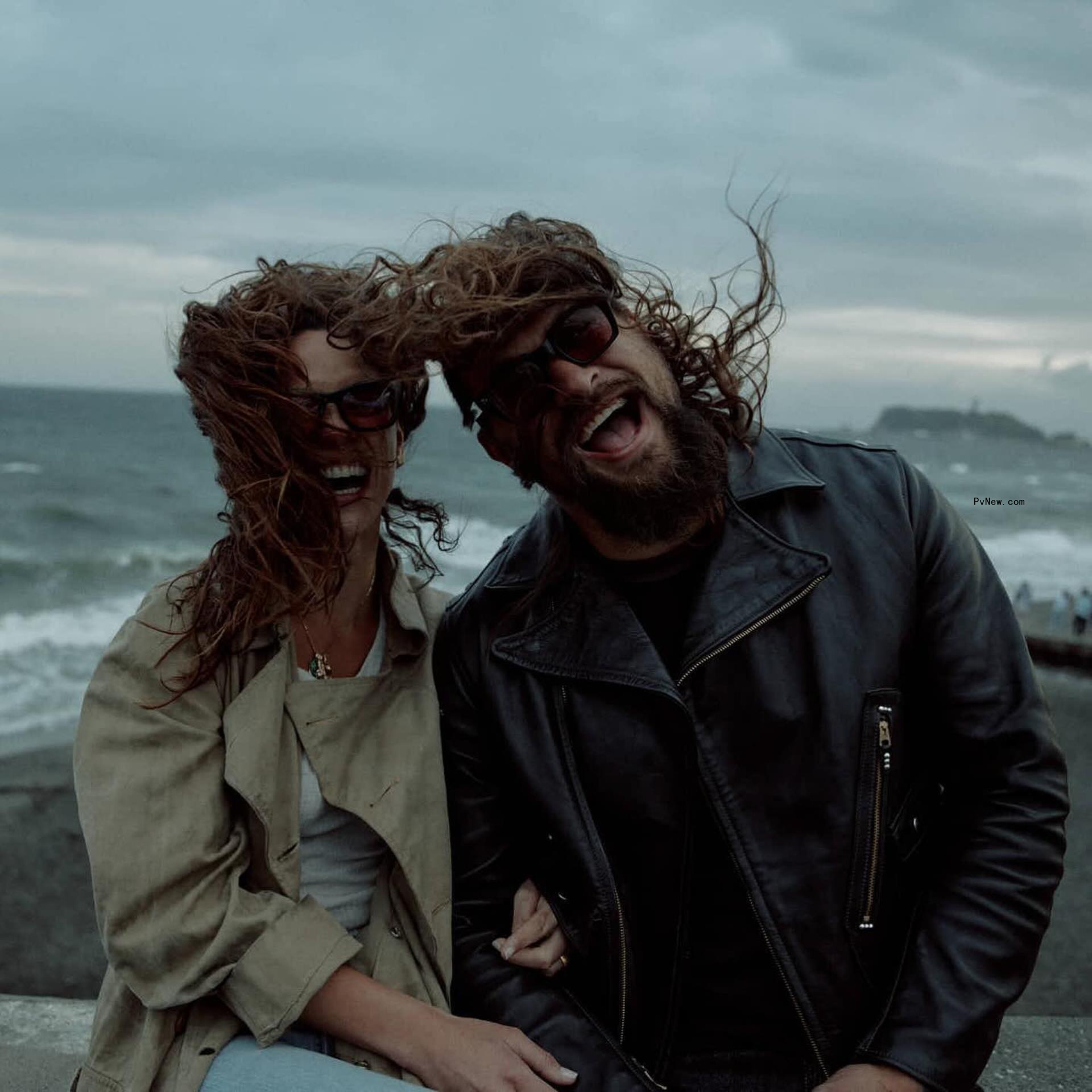 Jason Momoa and Adria Arjona by the ocean.