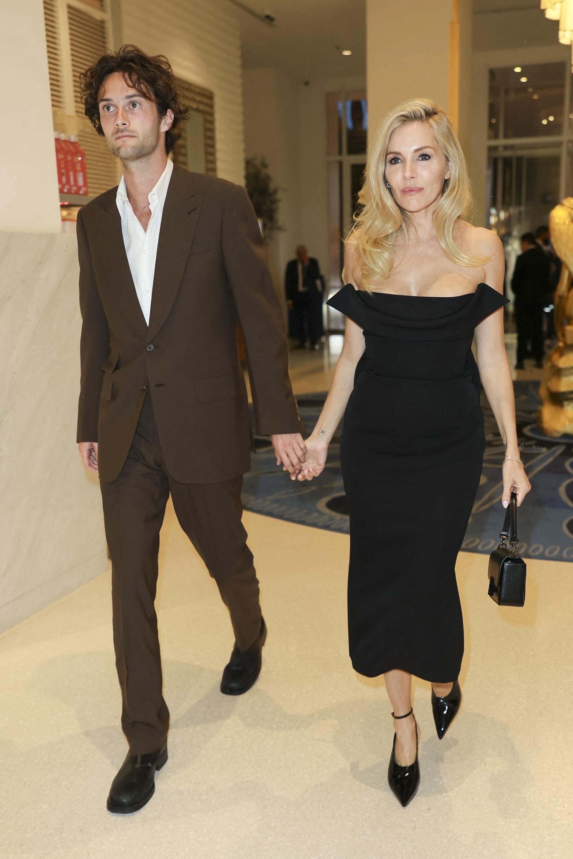 Sienna Miller and Oli Green holding hands. 