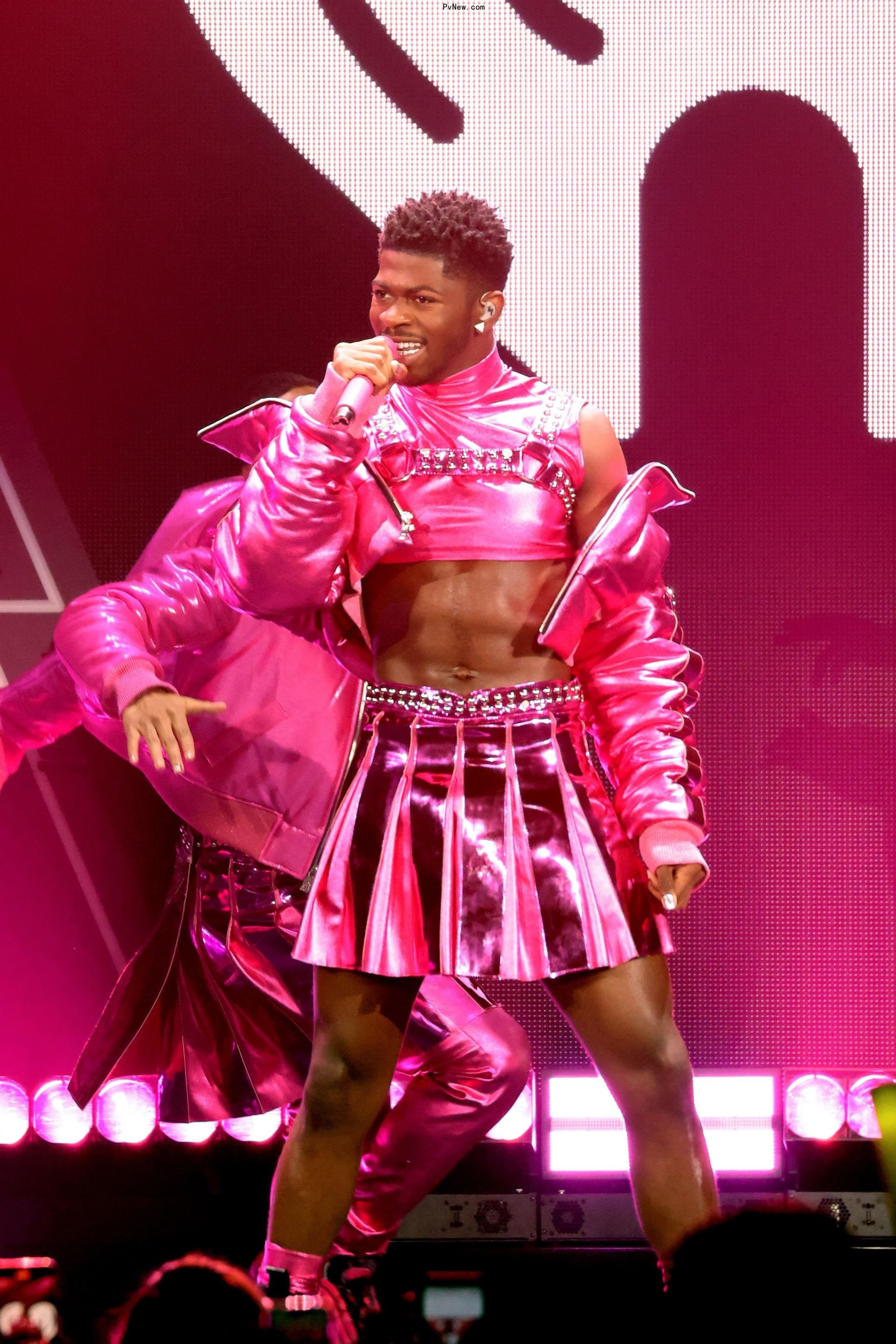 lil nas x performing on stage in a hot pink outfit