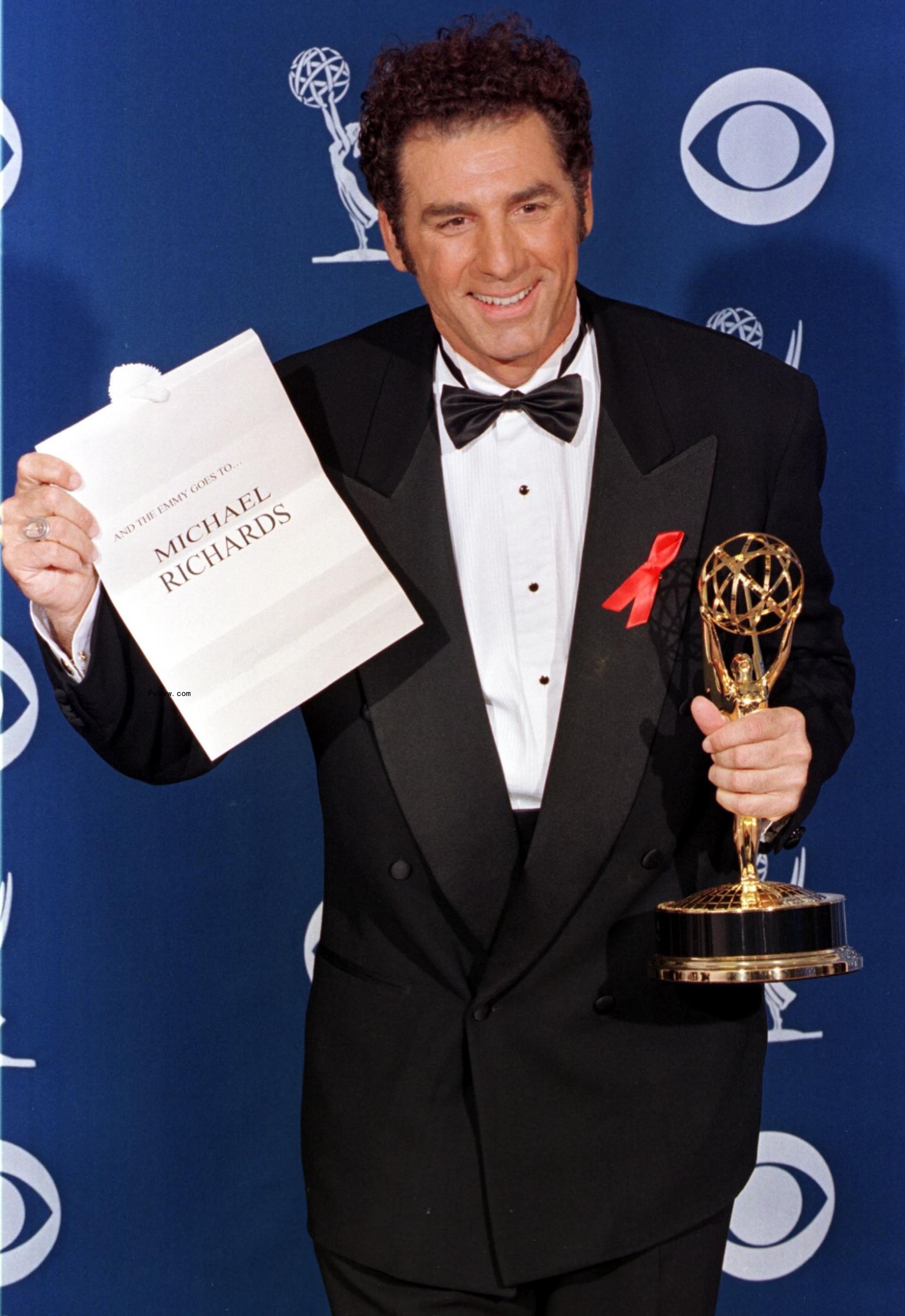 Michael Richards holding an Emmy and an envelope revealing his name as winner