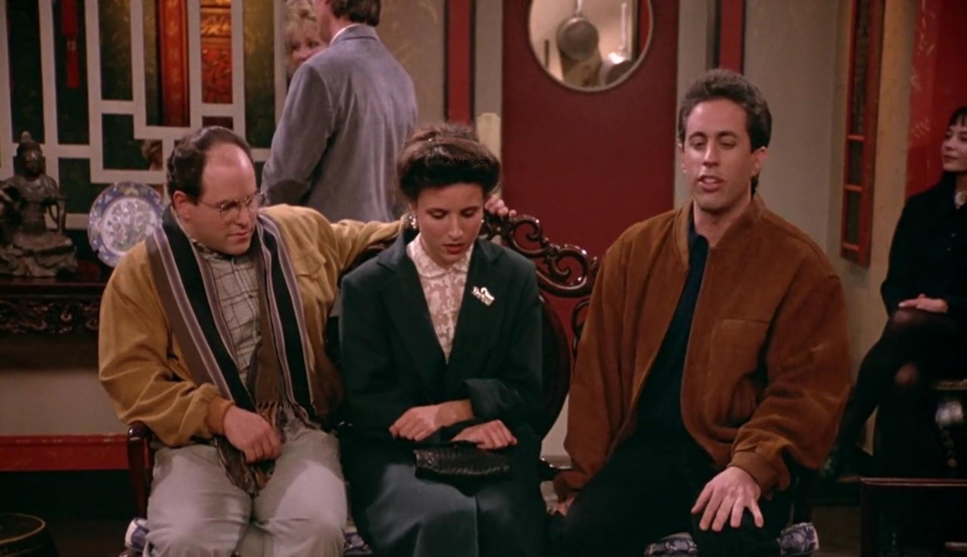 Jason Alexander, Julia Louis-Dreyfus and Jerry Seinfeld sitting on a bench in a restaurant 