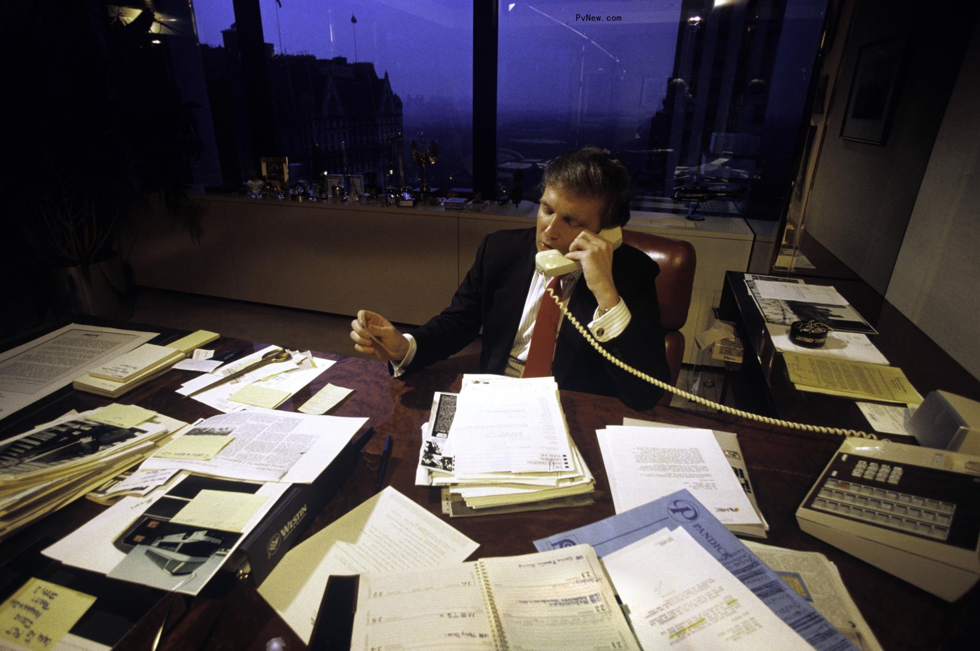 Do<i></i>nald Trump on the phone while sitting at an office desk.