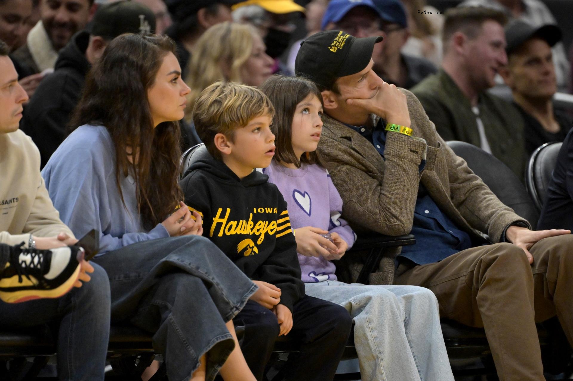 Mila Kunis and Ashton Kutcher with their kids, Wyatt and Dimitri, watching basketball