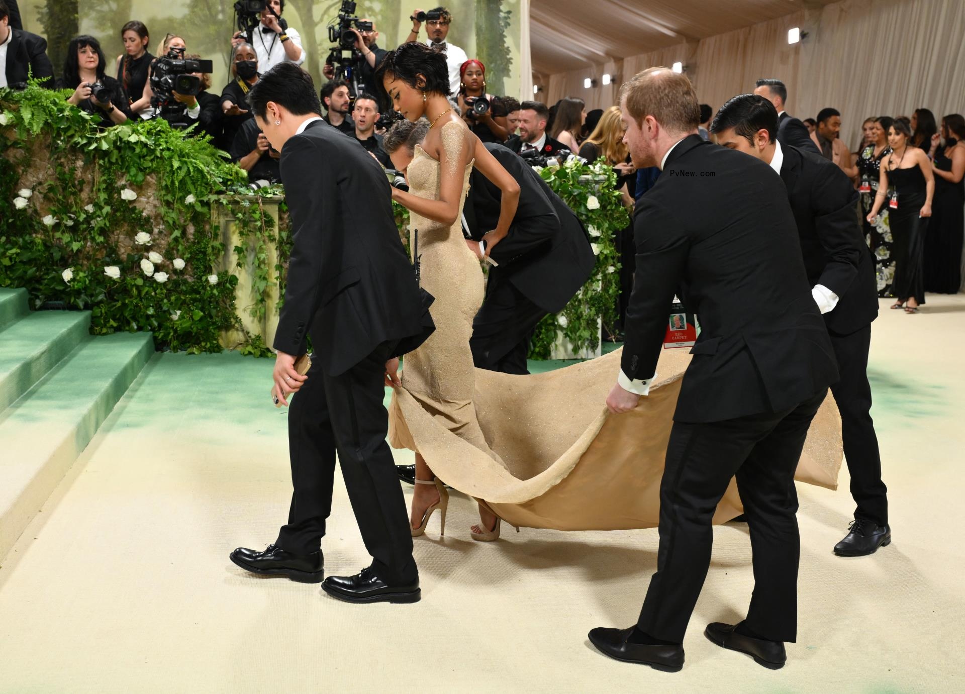 Tyla on the red carpet being helped with her train
