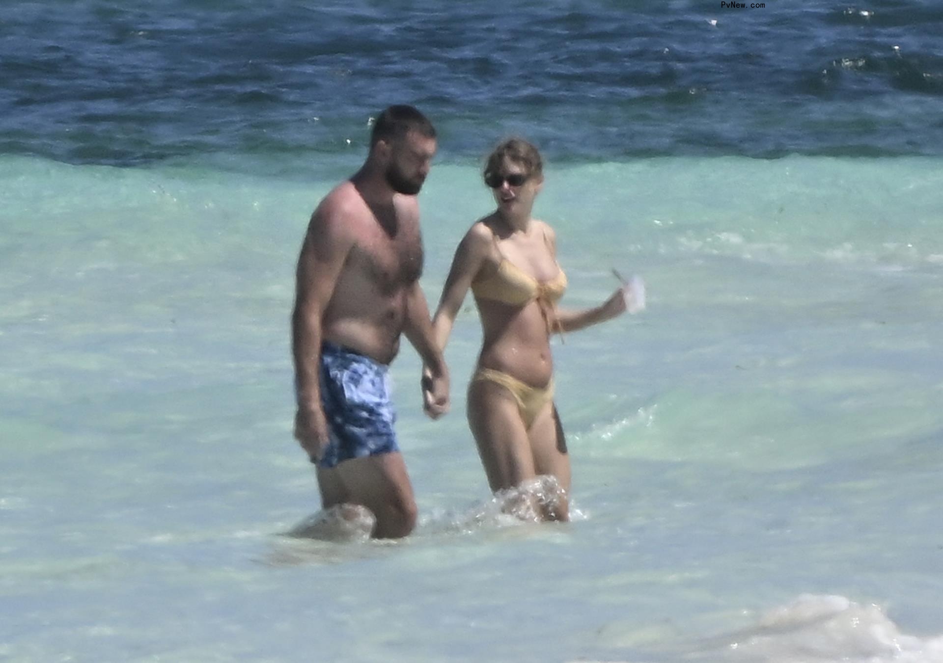 Taylor Swift and Travis Kelce going swimming in the Bahamas.