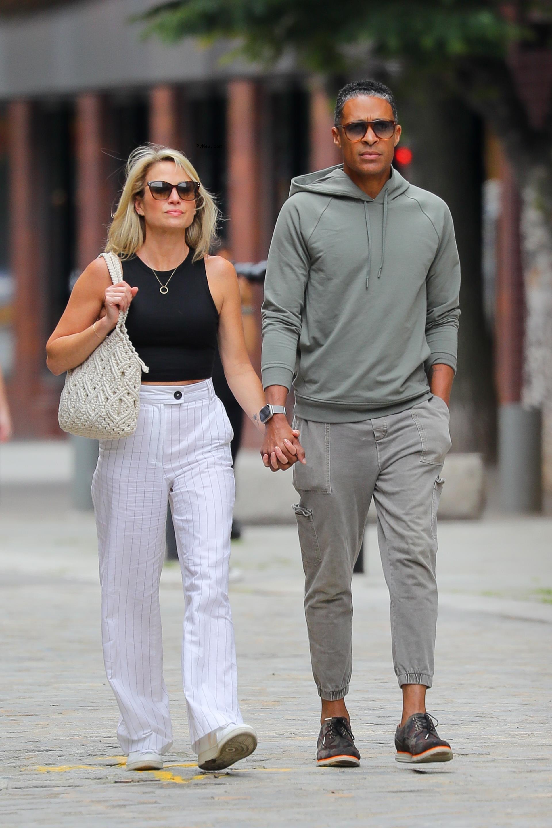 Amy Robach And TJ Holmes holding hands