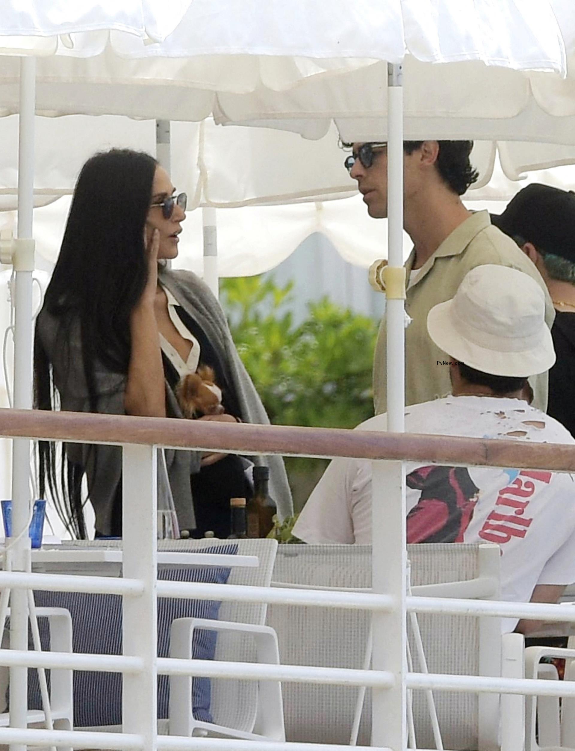 Demi Moore and Joe Jo<i></i>nas talking under an umbrella