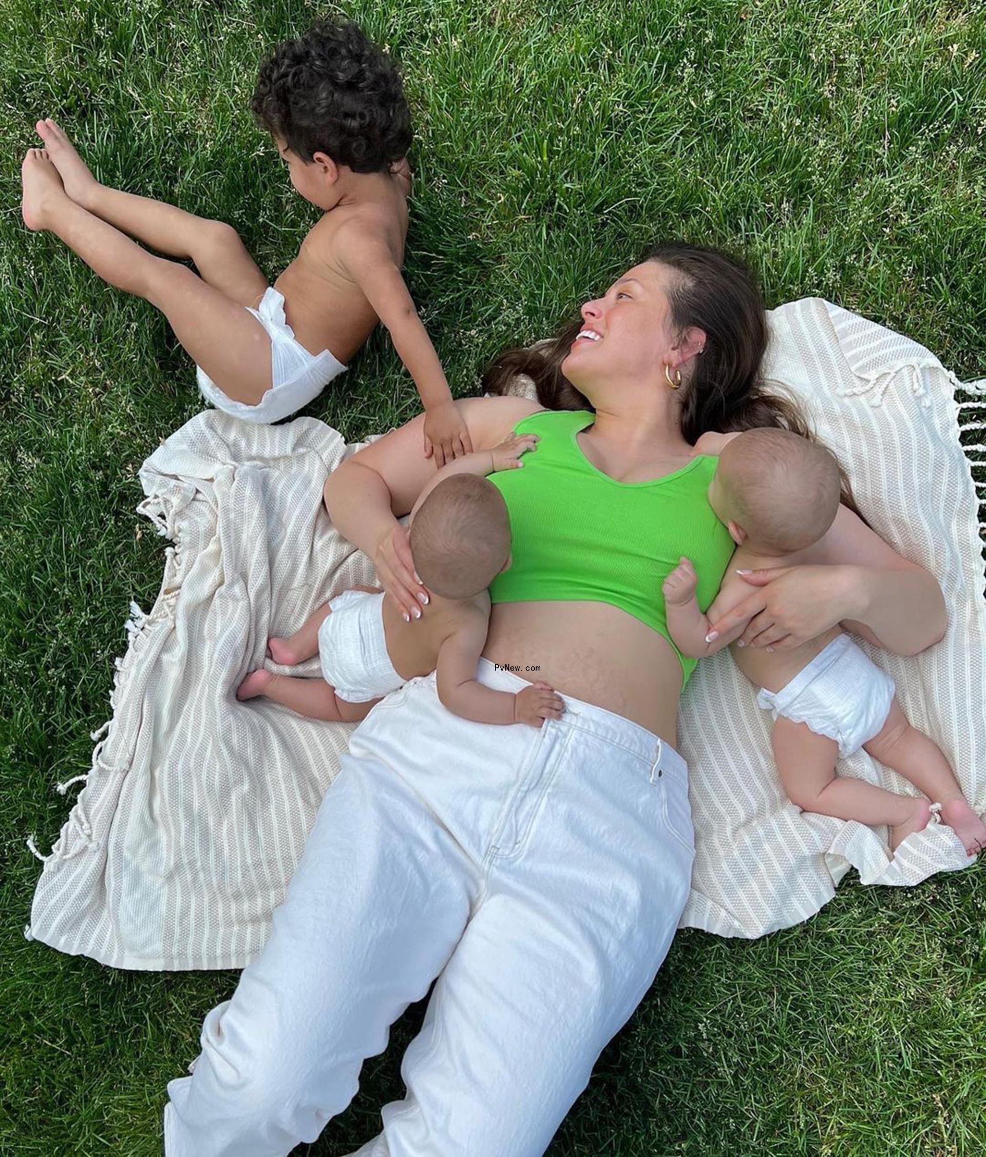 Ashley Graham with her three kids on a picnic blanket. 