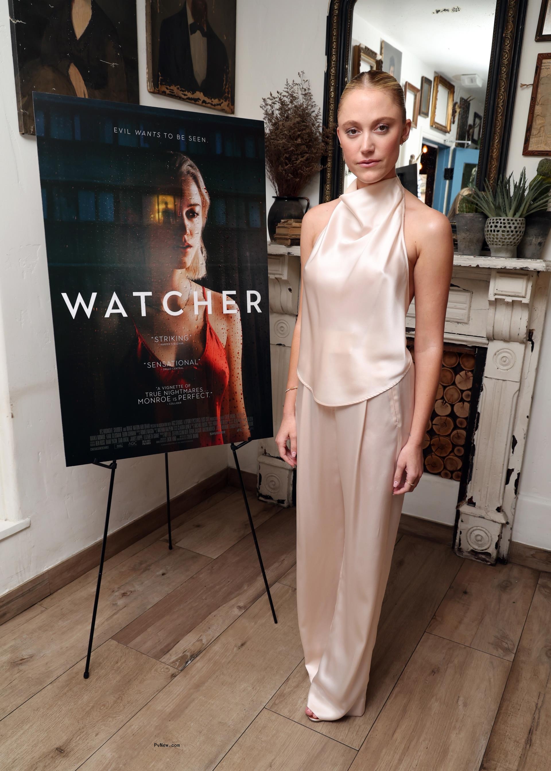 Maika Mo<i></i>nroe posing in front of a movie poster