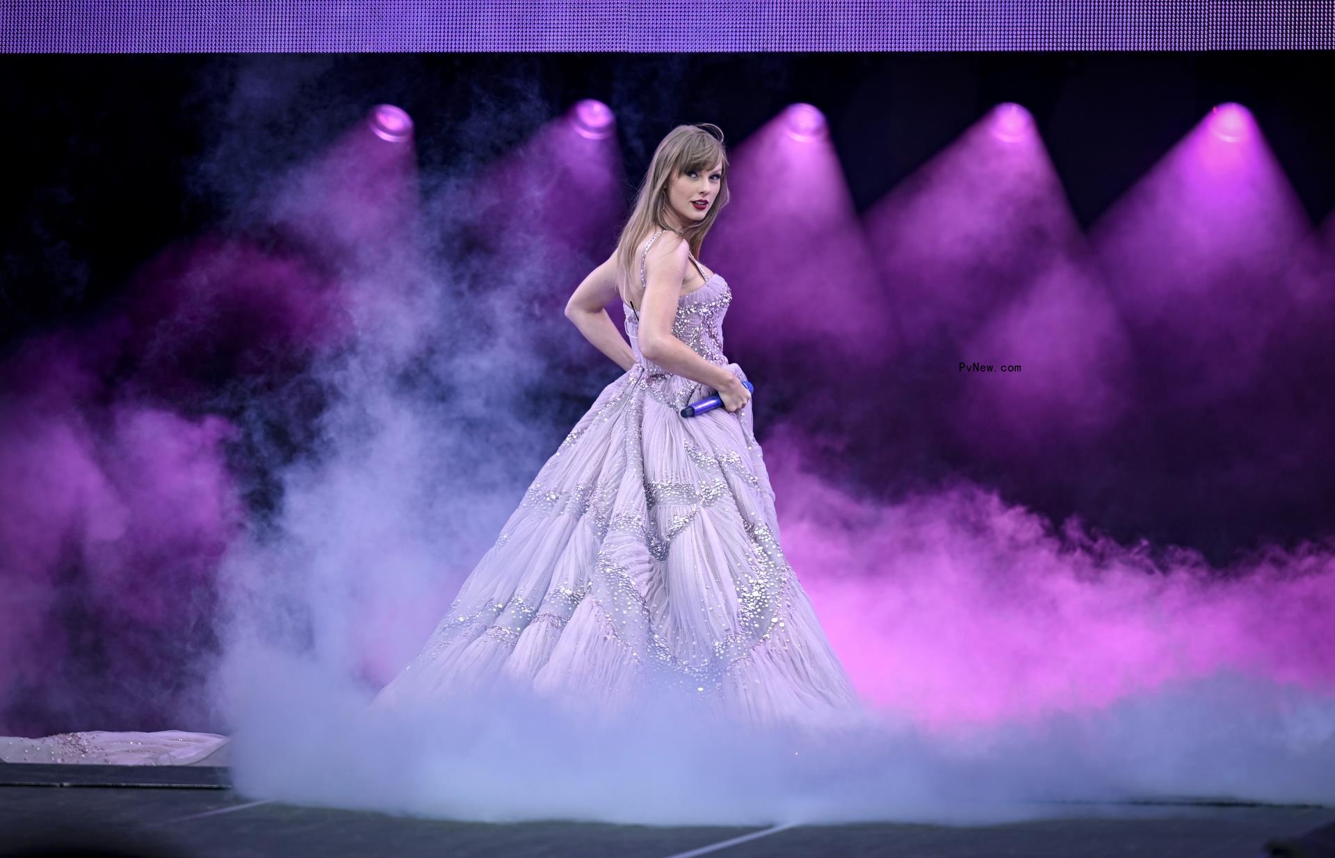 Taylor Swift o<i></i>nstage in a big purple dress.