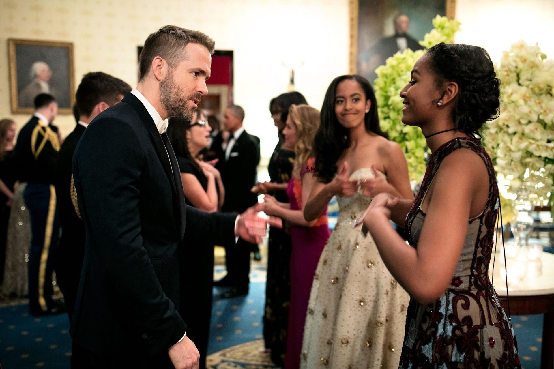 Malia and Sasha Obama speak with Ryan Reynolds in 2016.