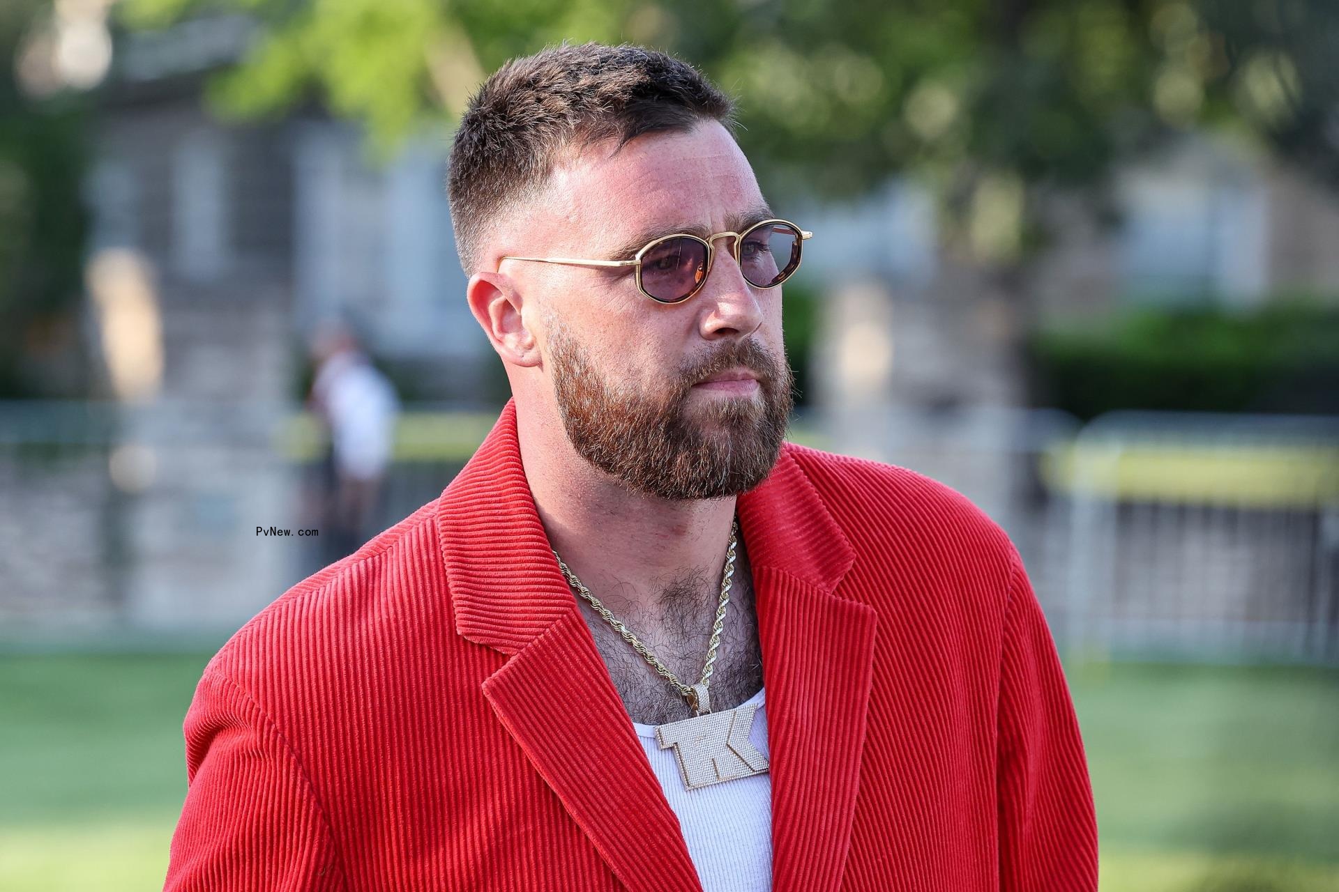Travis Kelce wearing a red suit at the Chiefs Super Bowl ring ceremony